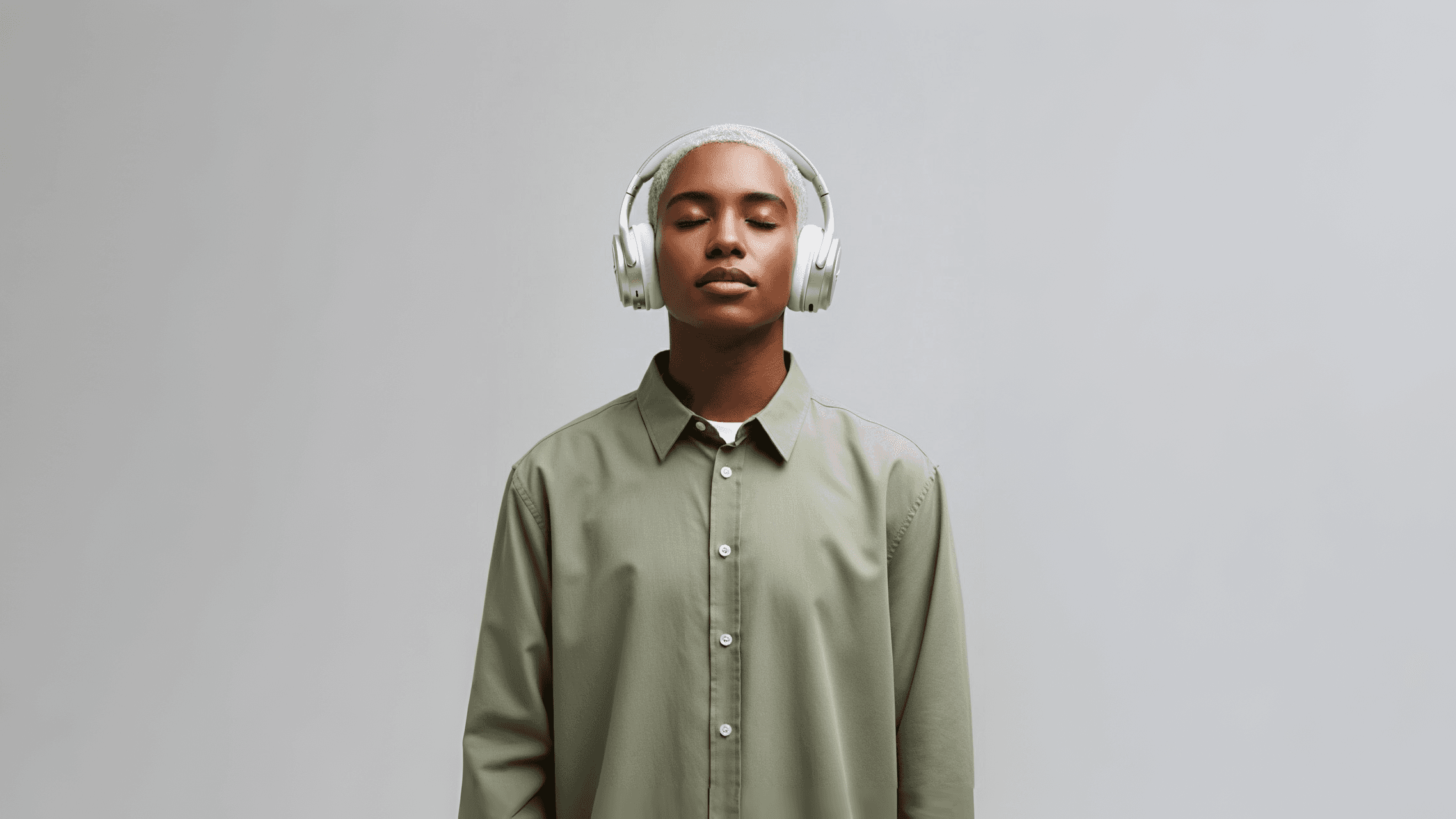 Man wearing silver headphones listening to music.