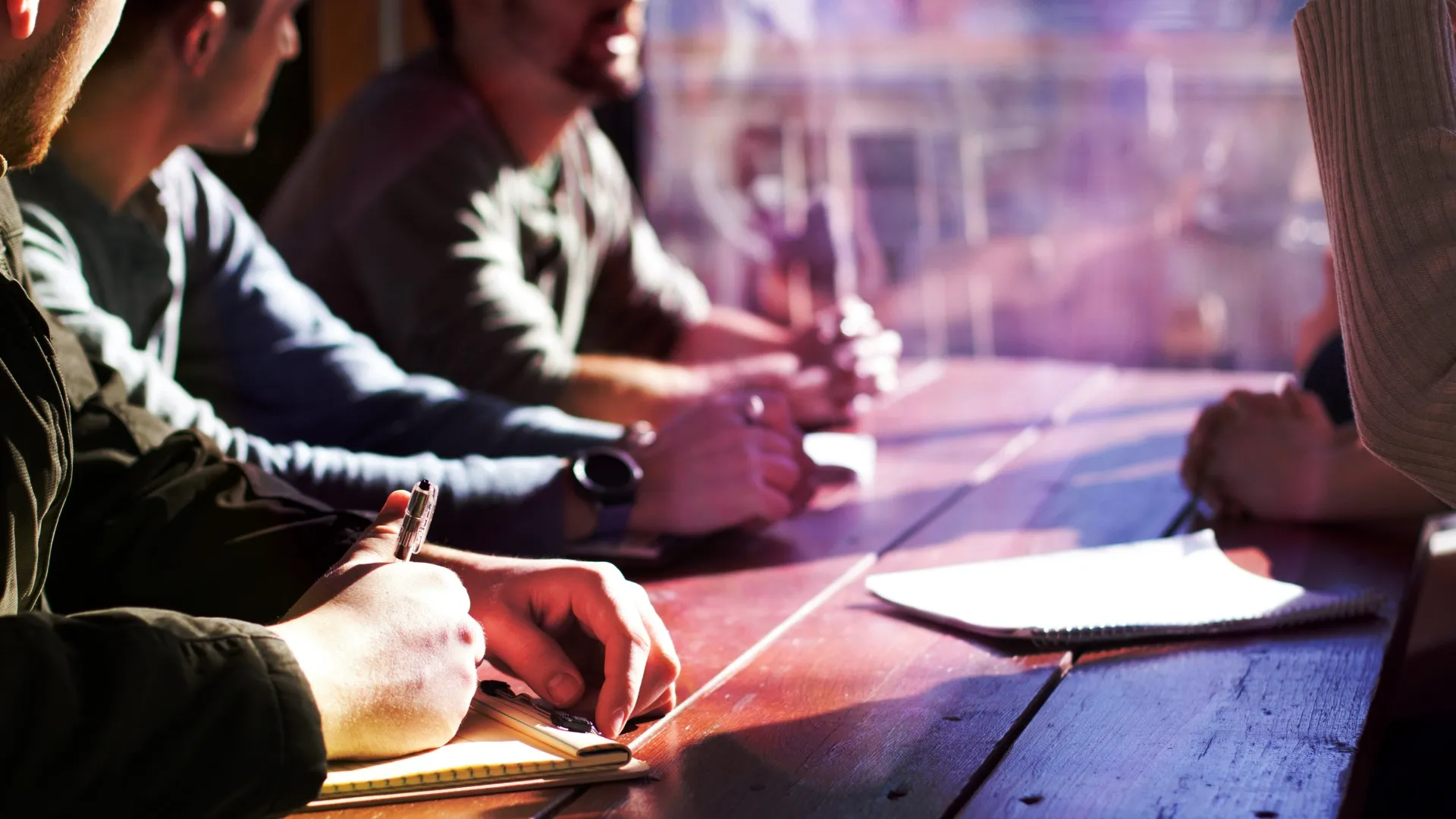 Close up of group of people sitting at a table during a meeting
