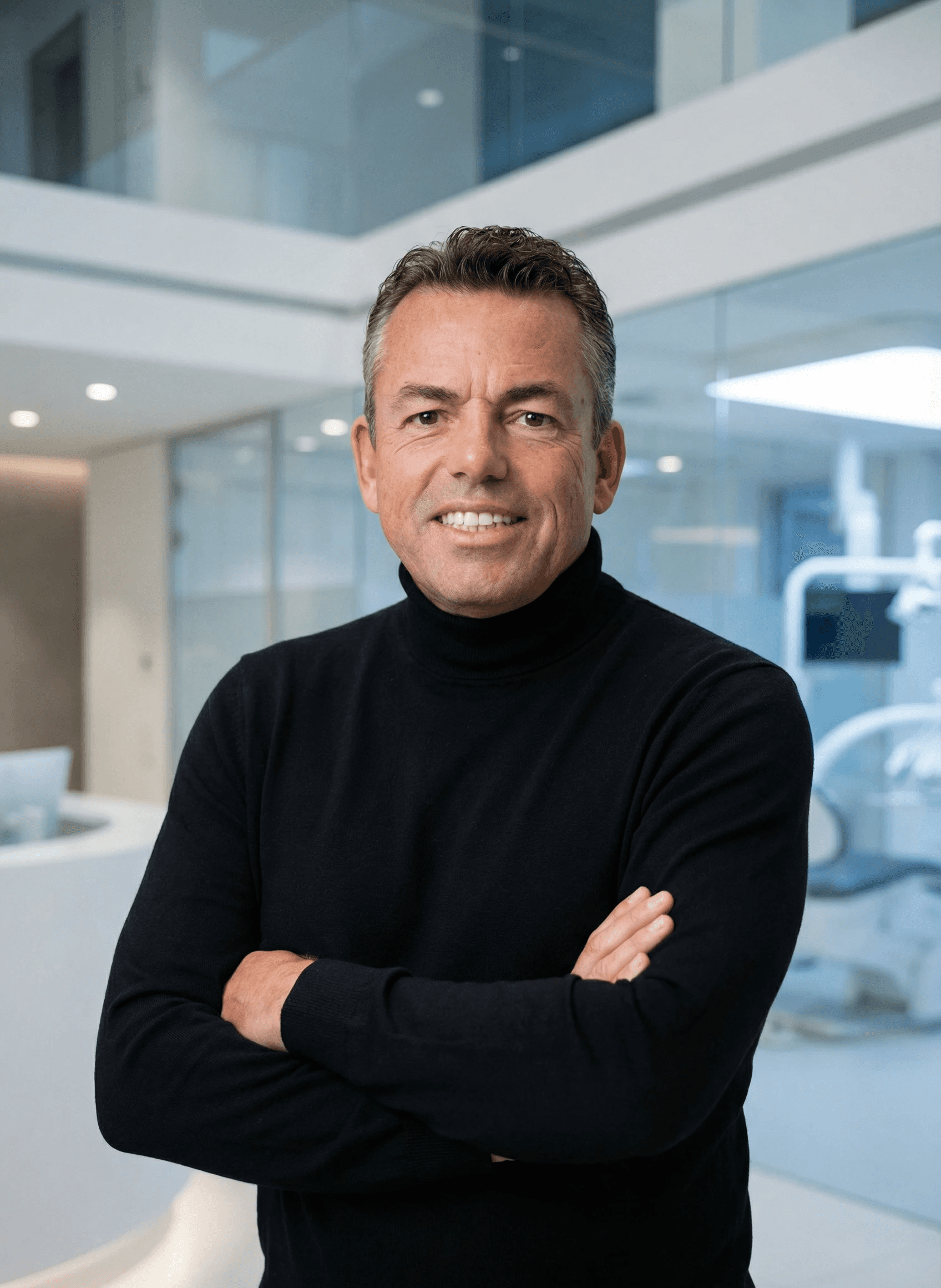 Woman with a short haircut smiling confidently, wearing a blazer and standing in warm natural light with modern architecture behind her.