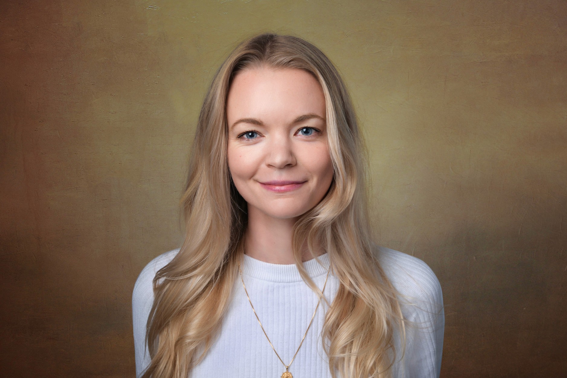 Clean studio headshot of blonde white woman with center part