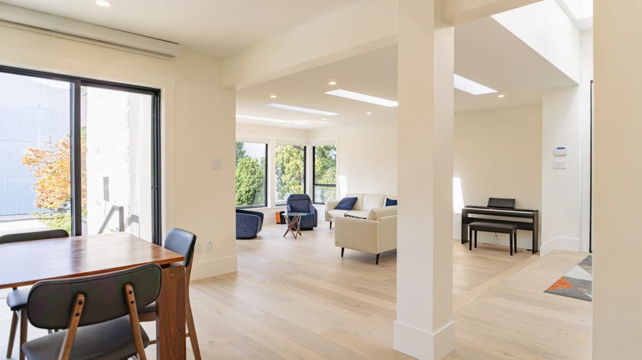 Spacious open floor plan showcasing living room, dining area, and piano nook with abundant natural light in Metro Vancouver custom home