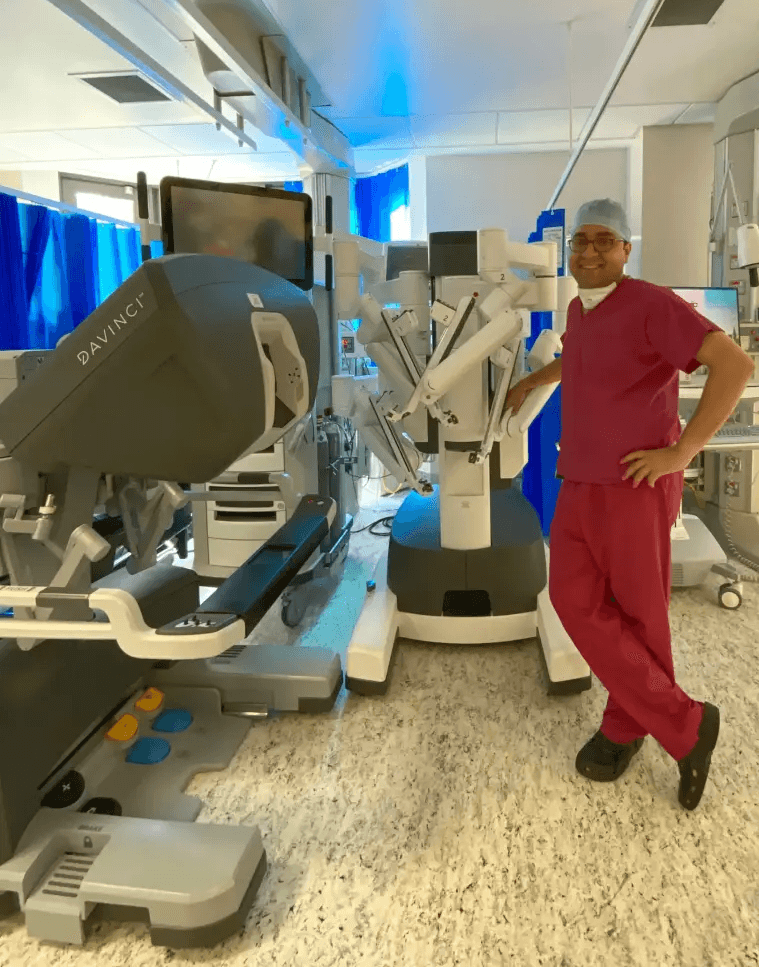 डॉ. तुषार अपने लंदन ट्रेनिंग के दौरान da Vinci robotic सिस्टम के साथ पोज़ करते हुए।