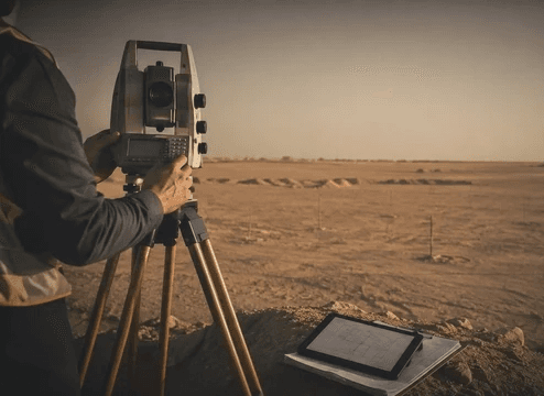 مهندس مساحة يستخدم جهاز محطة رصد ميدانية لاستخراج قرار مساحي لأرض في الرياض