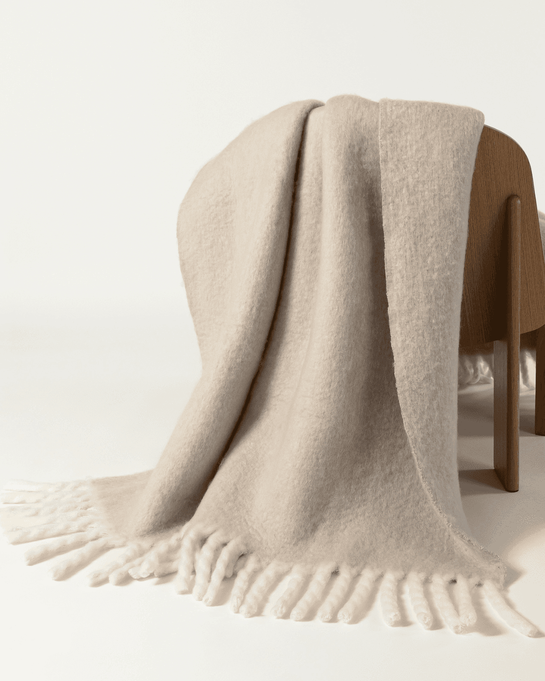 Faux mohair blanket in clay/moon draped over wooden chair