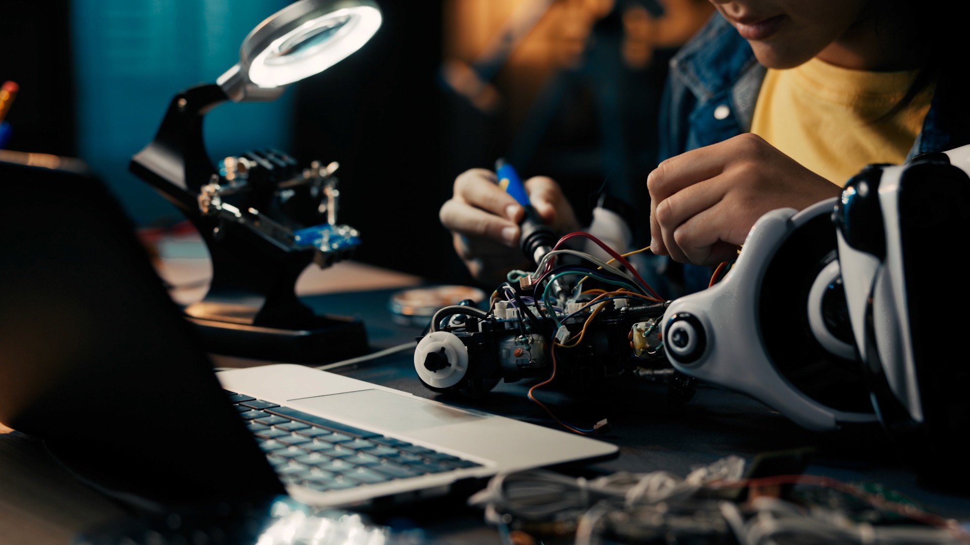 A young student working on a robot arm at a desk, illustrating future-focused education and creativity for Garanti BBVA ‘Future Here’ project.