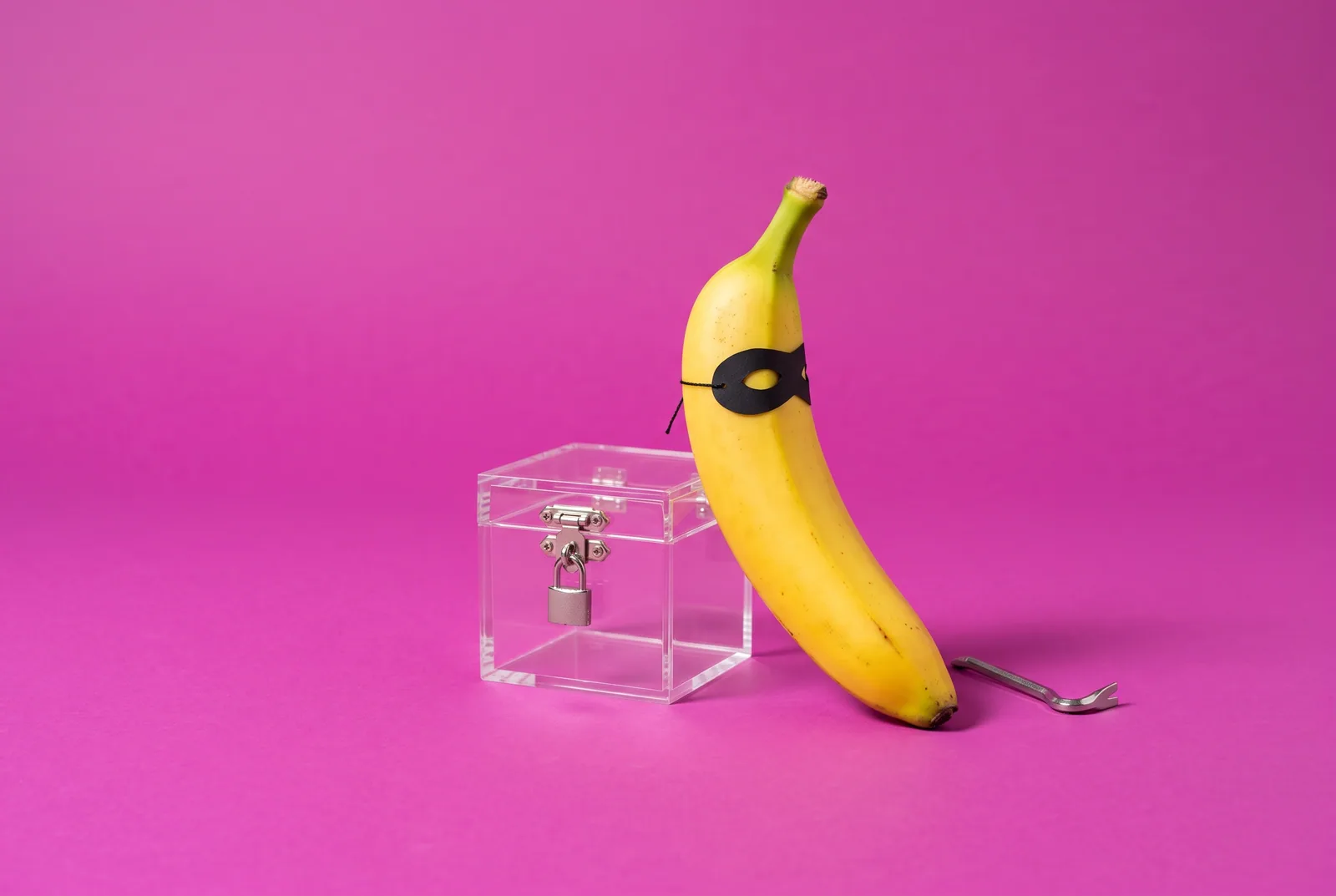 A banana in a burglar mask next to a locked box and tiny crowbar, testing a permanent block on adult sites on your phone