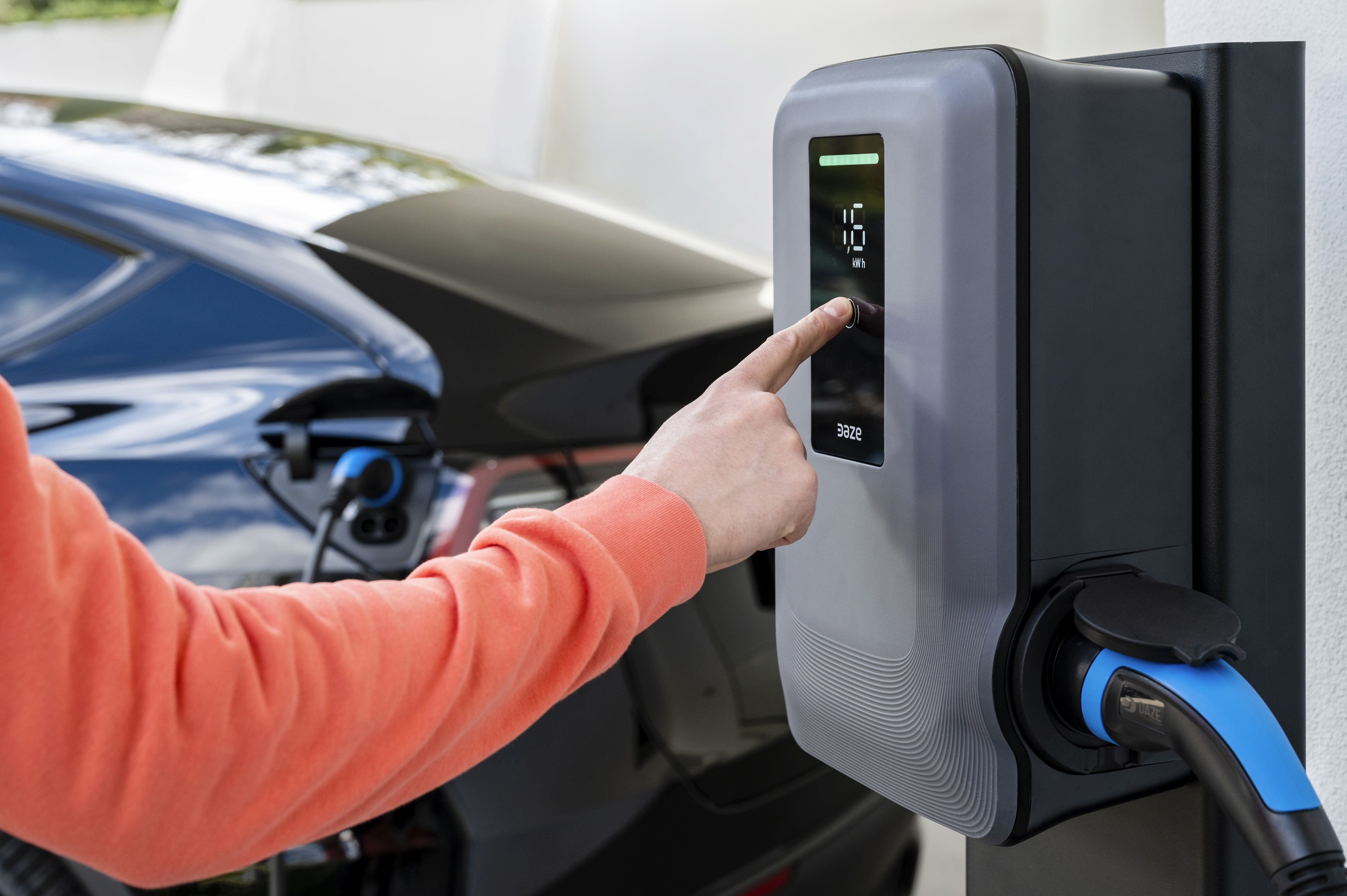 Ricarica auto elettrica con Dazebox: persona utilizza touchscreen per avviare la ricarica. 