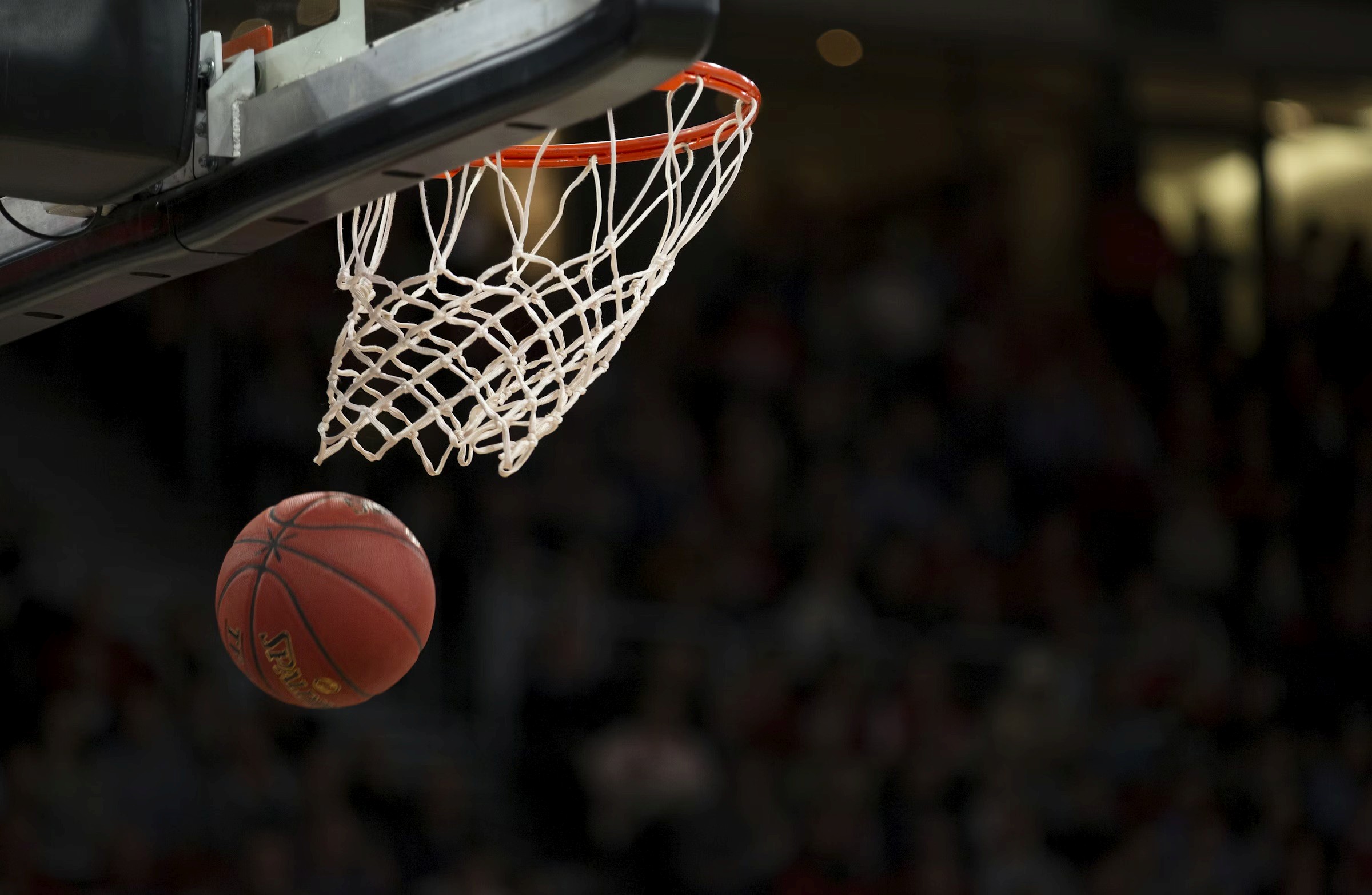 A basketball exiting a hoop after a clean swish by a Free Flow Player