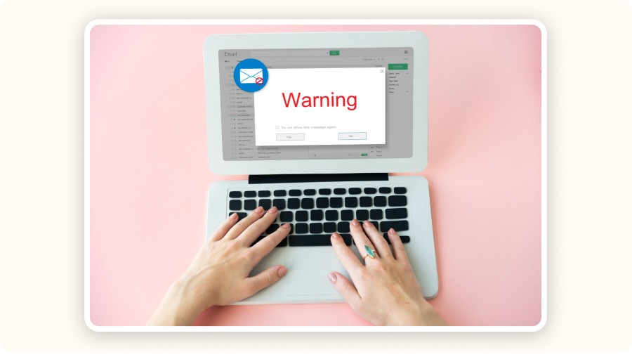 Person typing on laptop showing warning message about email issue or error