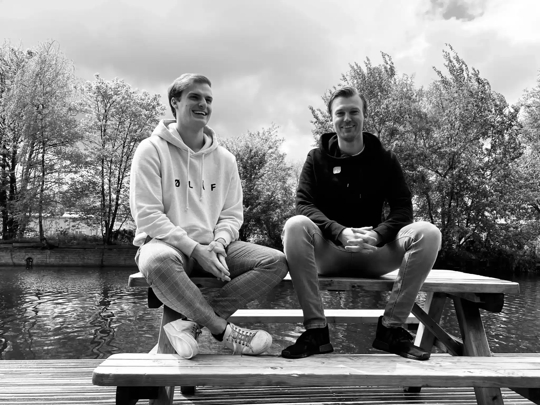 Black-and-white photo of Dylan Laseur and Robin Laseur on a picnic bench by the water