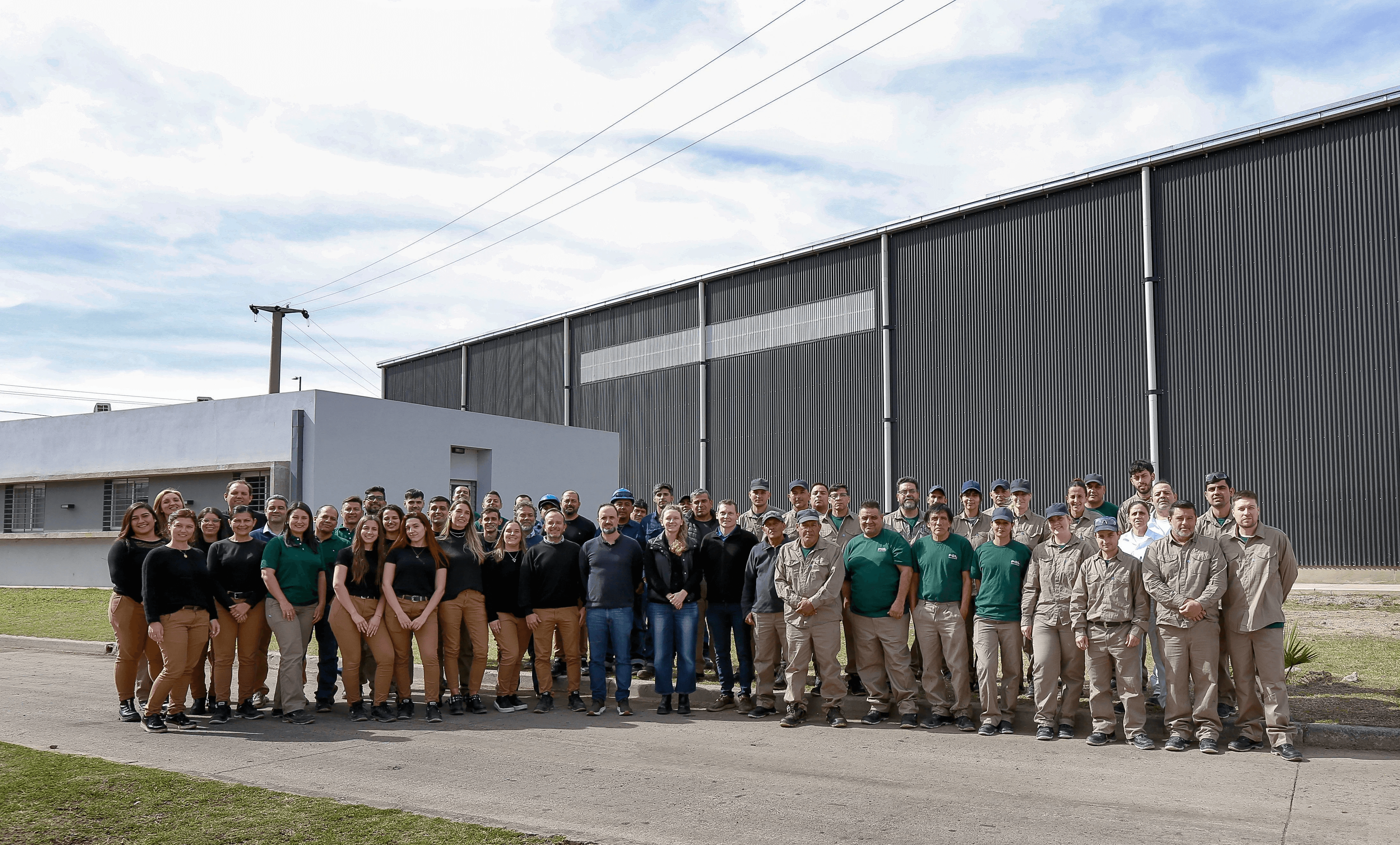 Equipo de trabajo de PQL frente a la planta industrial.