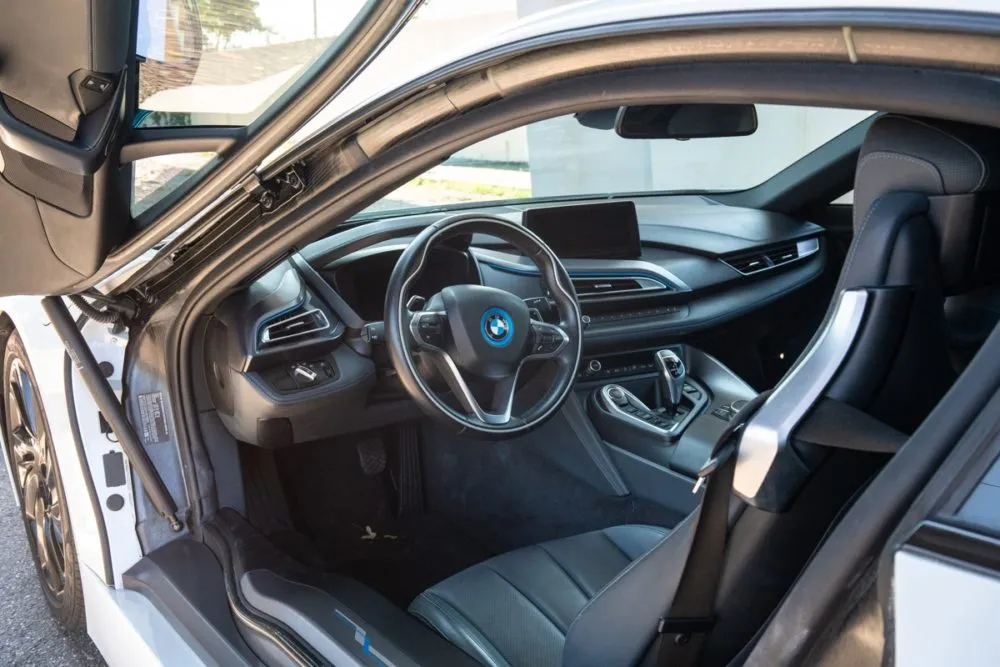 Interior shot of the BMW i8 from the passenger side, showcasing the minimalist center console and luxury details.