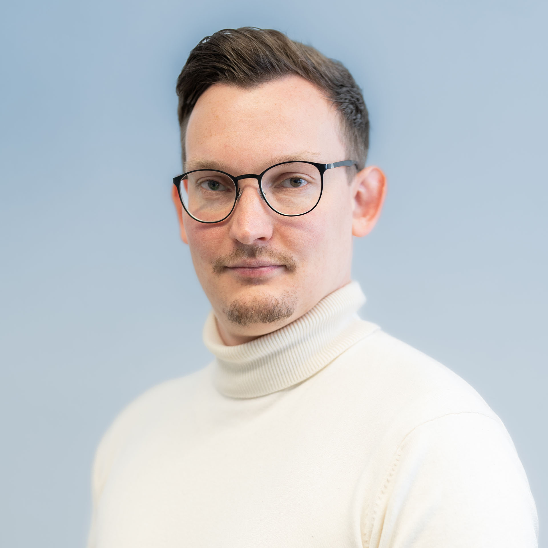 Portrait of a laughing person with curly hair wearing a white shirt