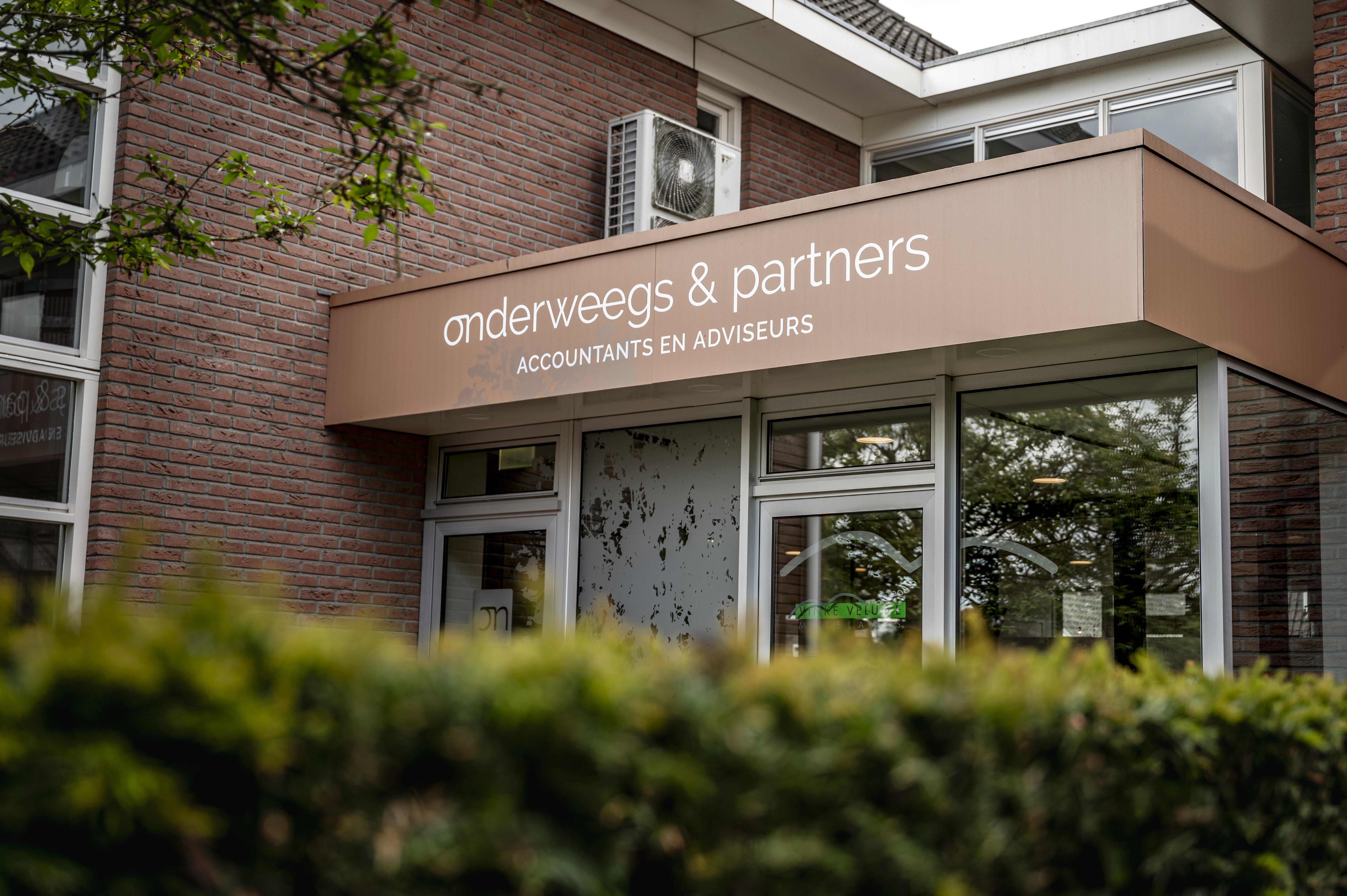 Handen typen op het toetsenbord aan een bureau
