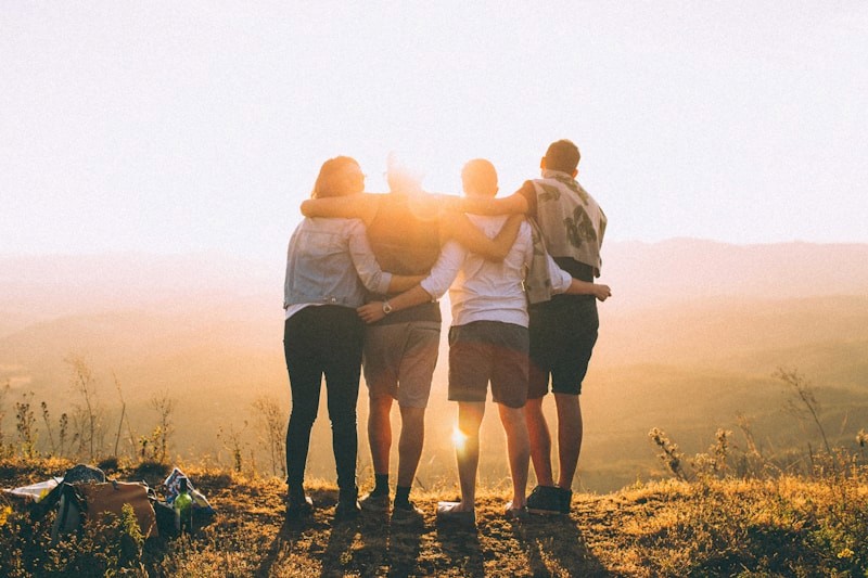 People supporting one another at sunset