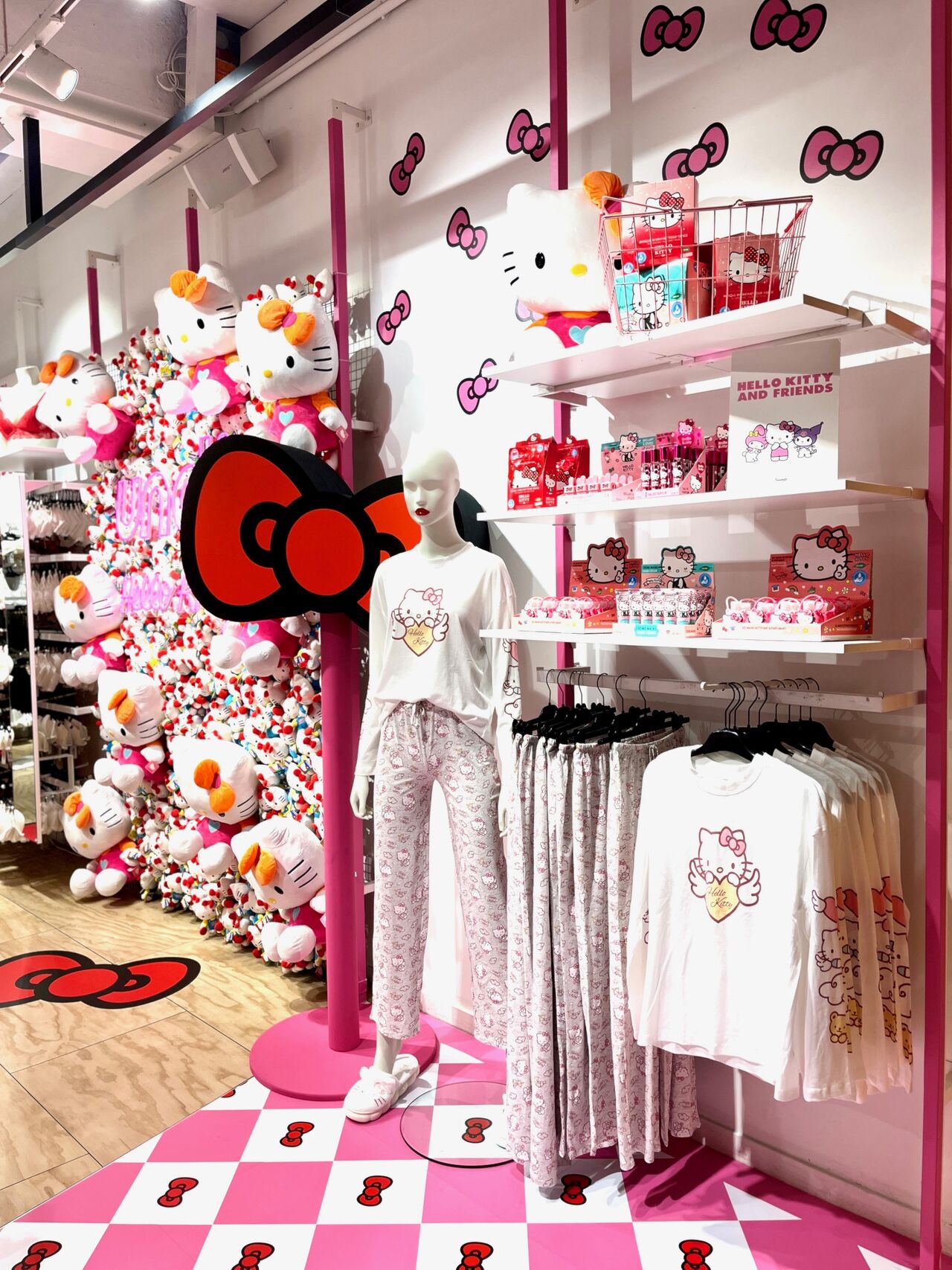 Présentoir de vêtements et accessoires Undiz x Hello Kitty avec mannequin et décor mural à l'effigie du personnage.