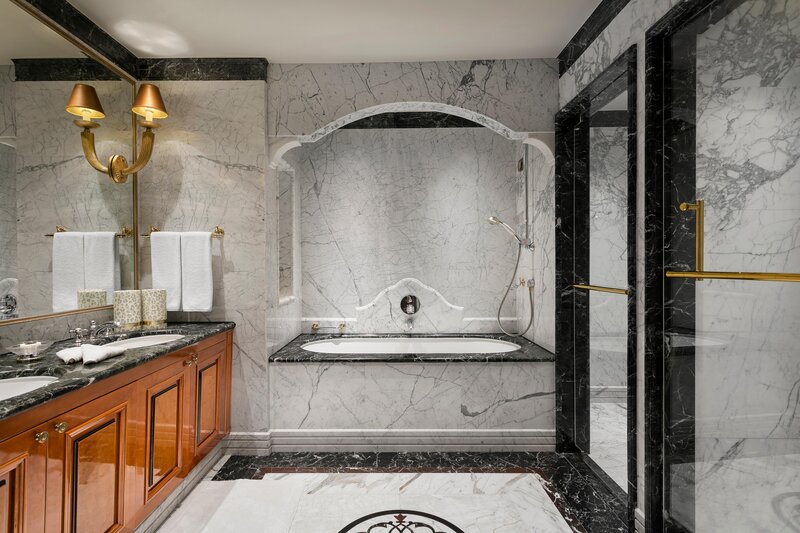 Bathroom with shower, branded amenities, makeup mirror, and hair dryer.