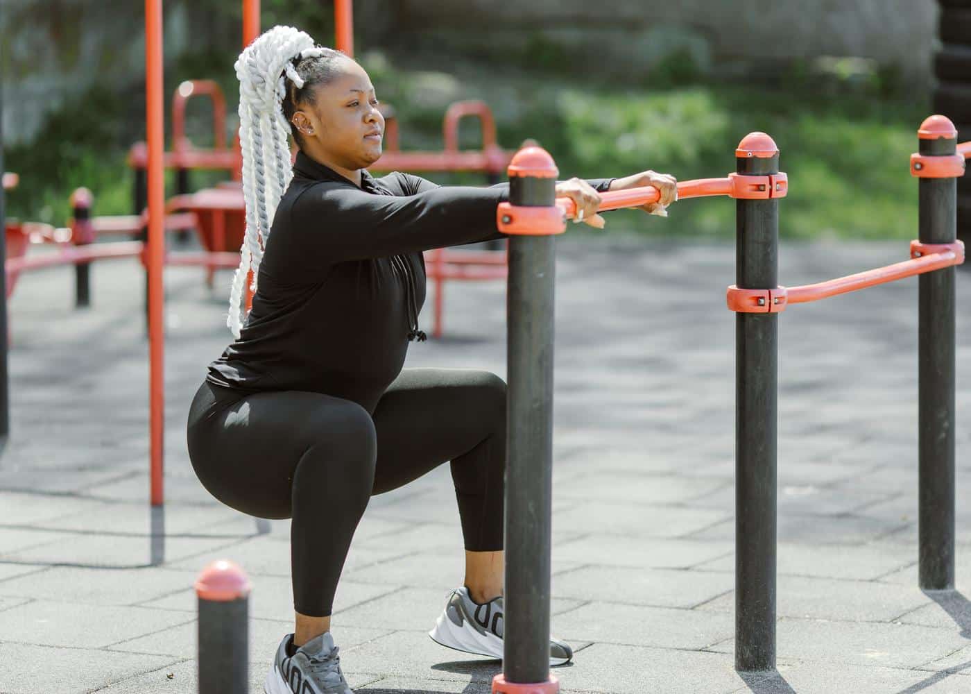 Woman doing a squat in outdoor fitness area
