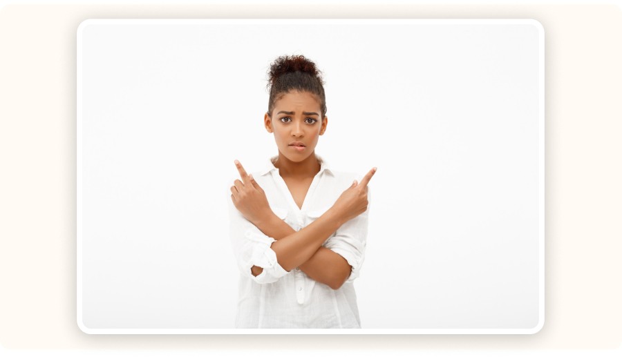 Woman crossing arms pointing both directions with confused expression on background