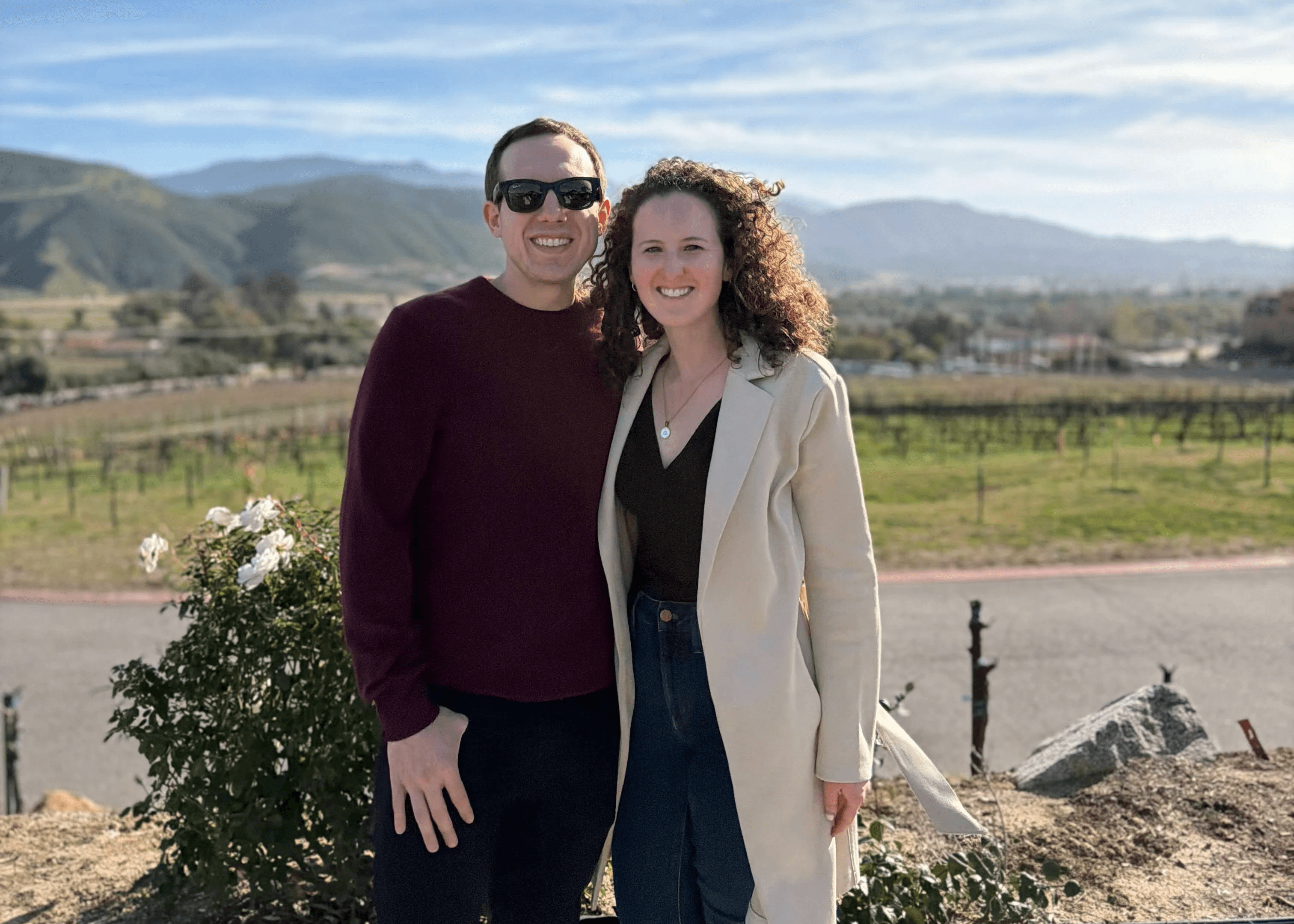 Picture of Theresa and her partner standing in a green environment with a mountain in the background