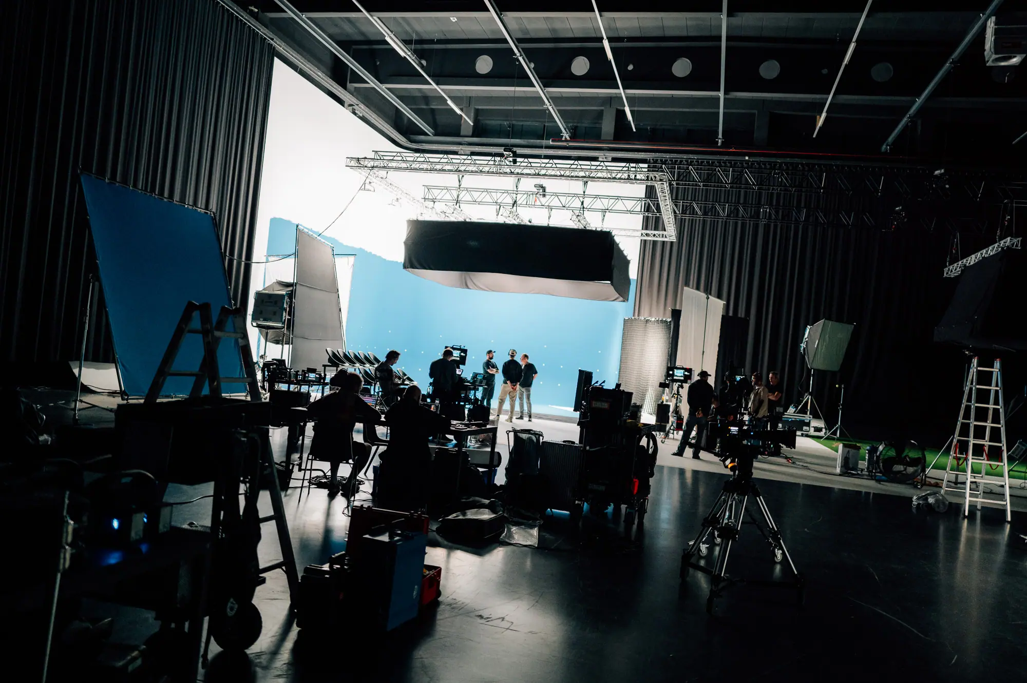 Large-scale studio production with blue screen setup and camera crew on set