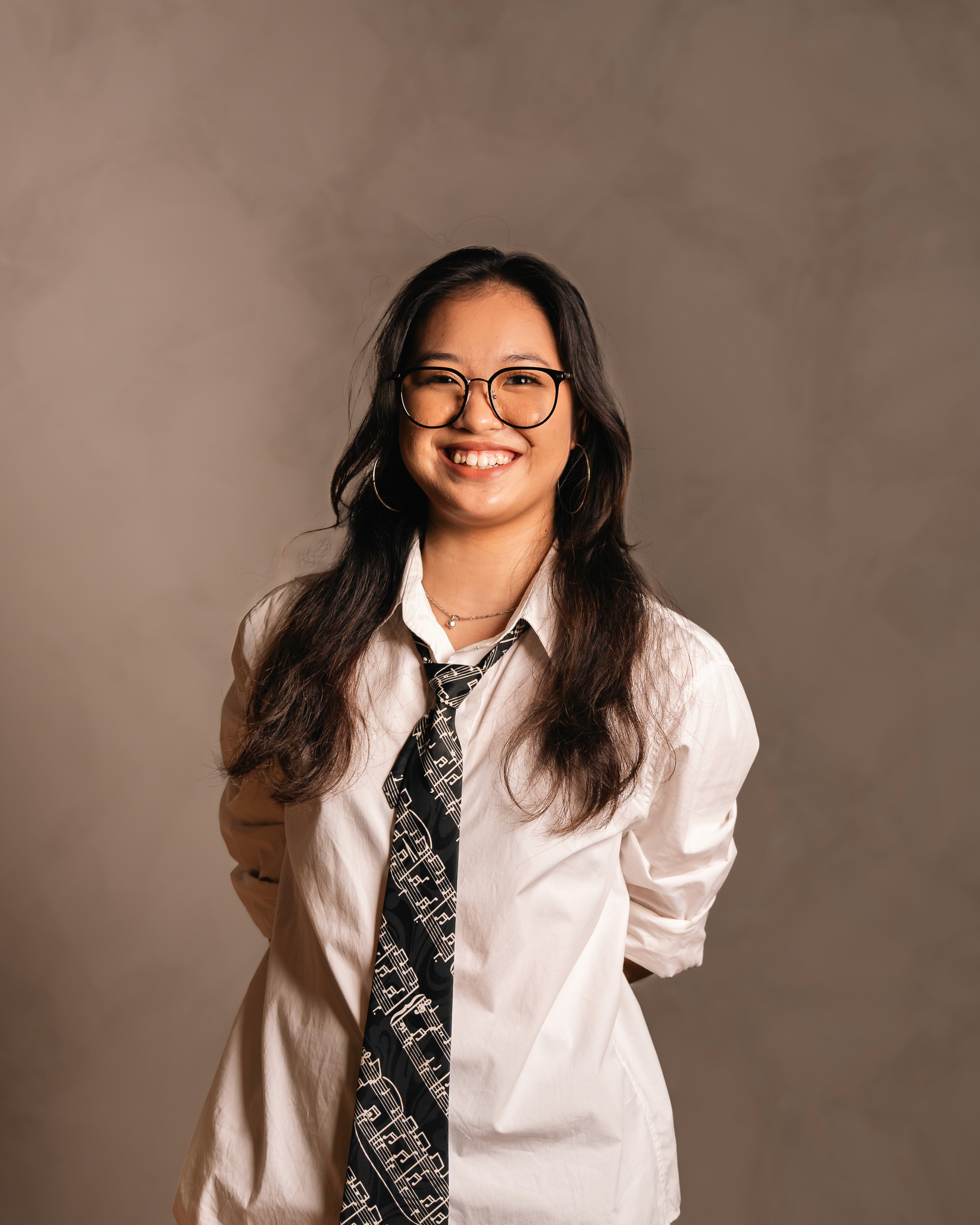 Smiling profile shot of Lana Lajarca with grey backdrop, captured by AKAR Studios