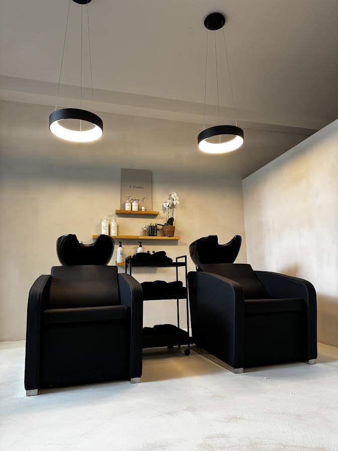 Zwei komfortable Haarwaschplätze mit schwarzen Sesseln in einem minimalistischen Raum