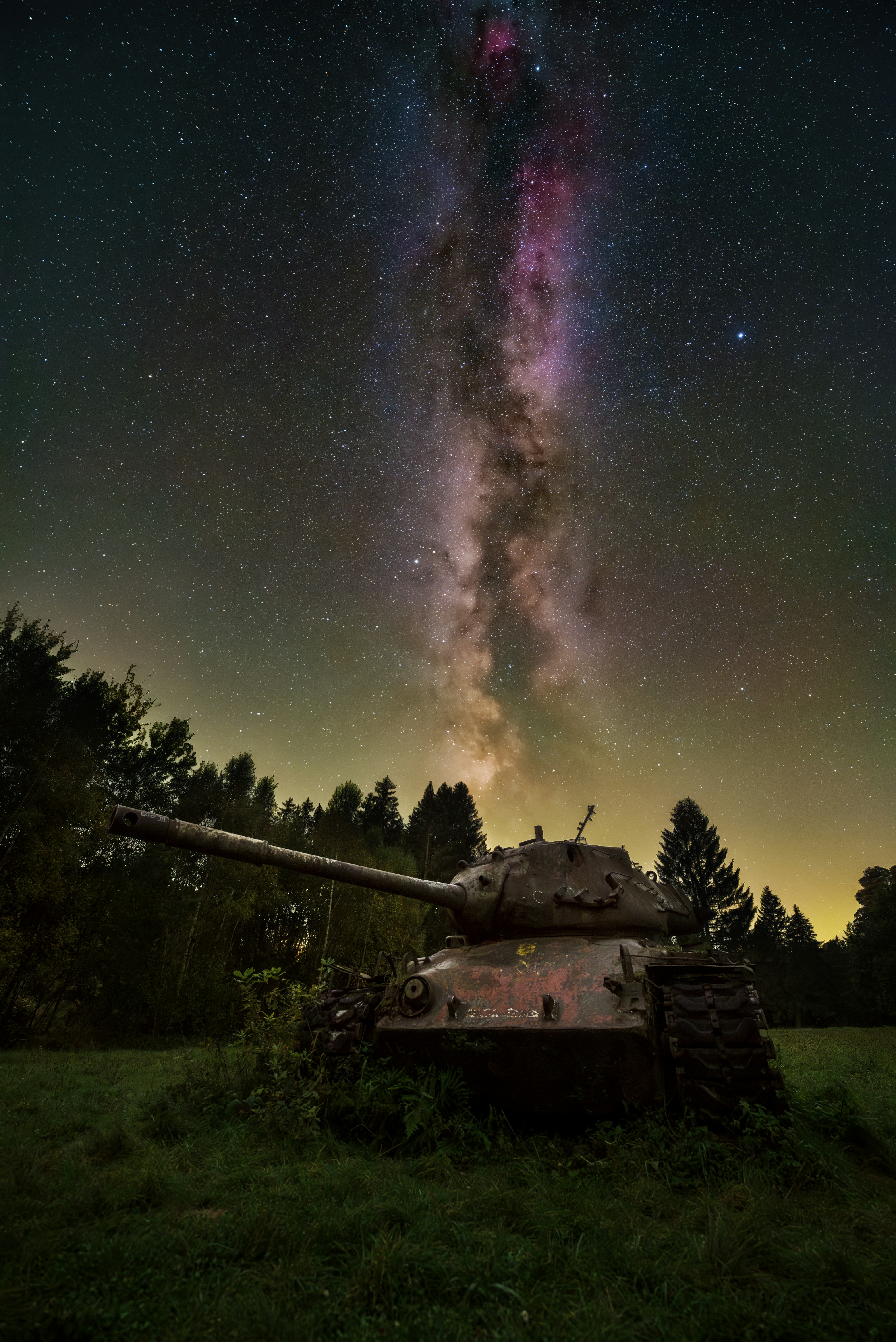 A tank sitting on top of a lush green field
