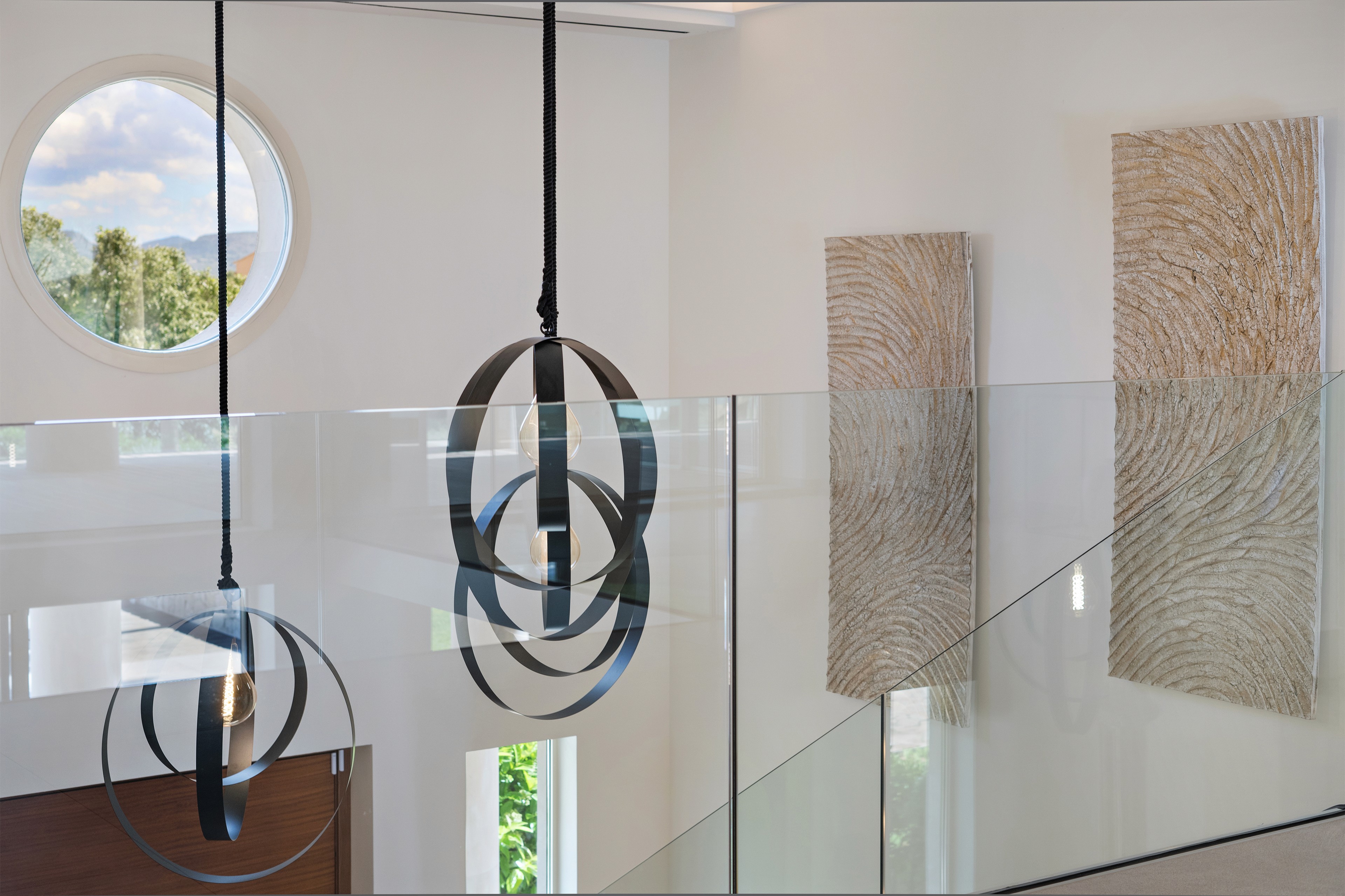 Eingangsbereich der Villa in Llombards mit Treppe, Designleuchten und minimalistischer Raumgestaltung