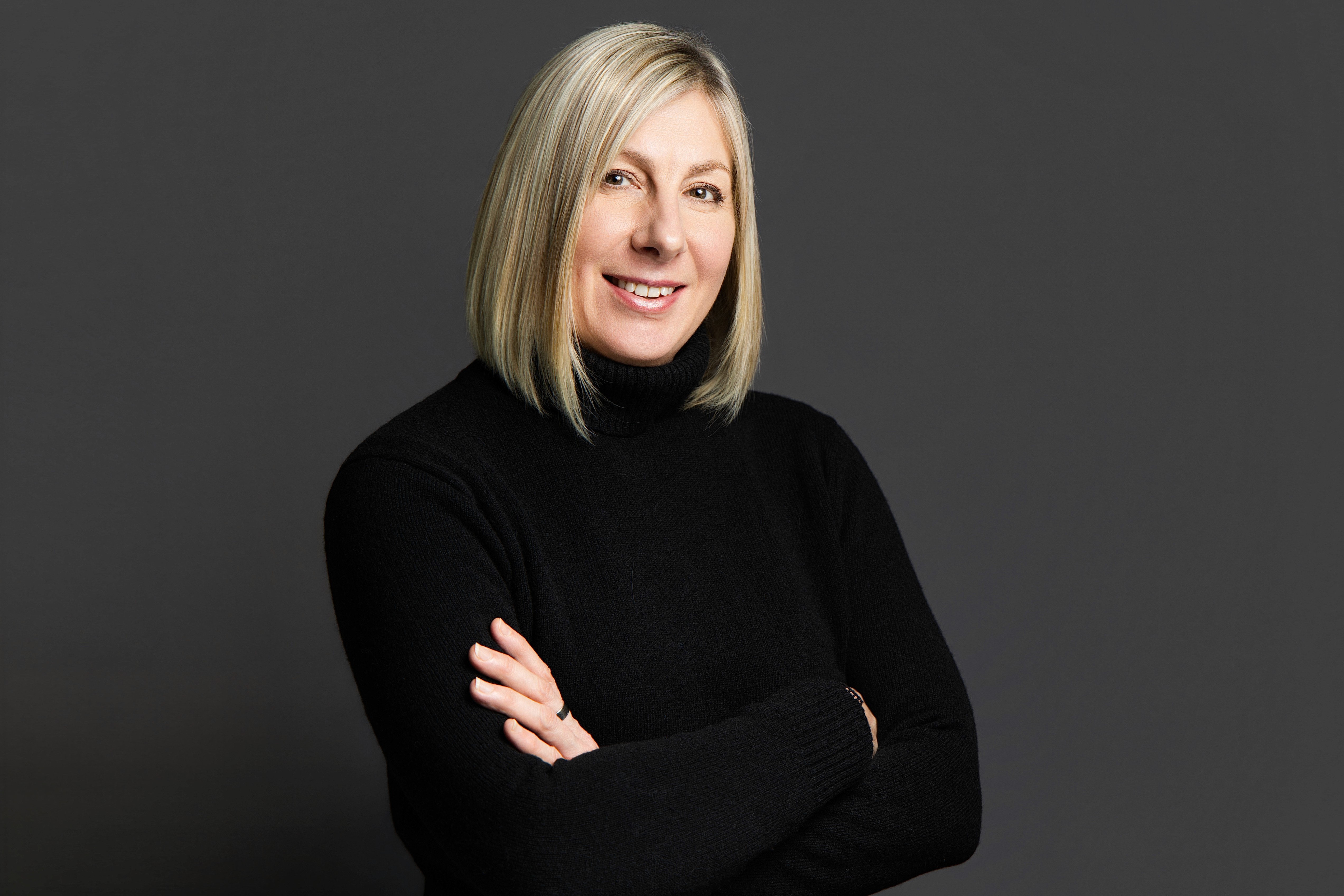 A young man in a white t-shirt stands against a light-colored background.