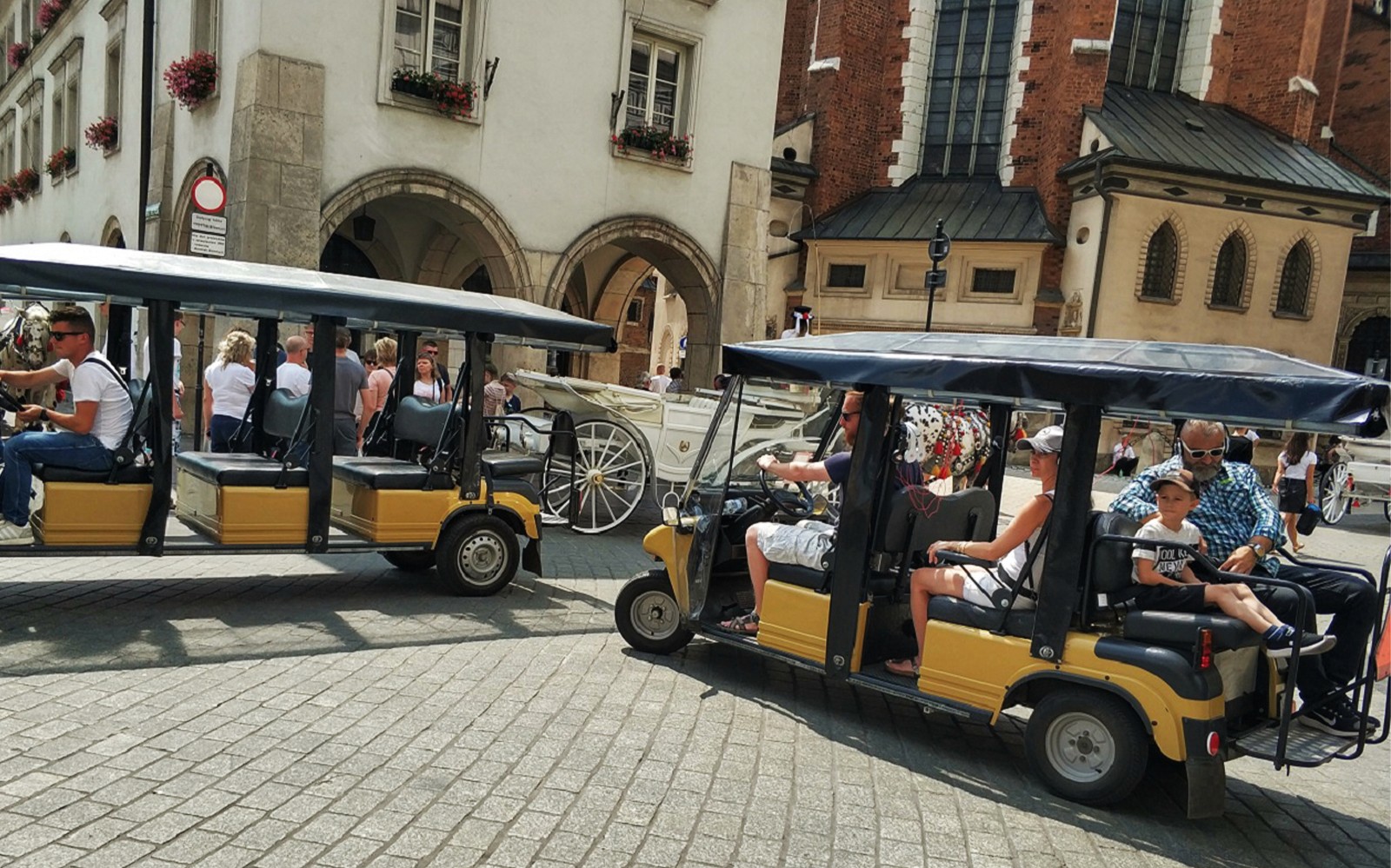 Golfkarretjes maken een tour door de oude binnenstad van Krakau, langs historische gebouwen.