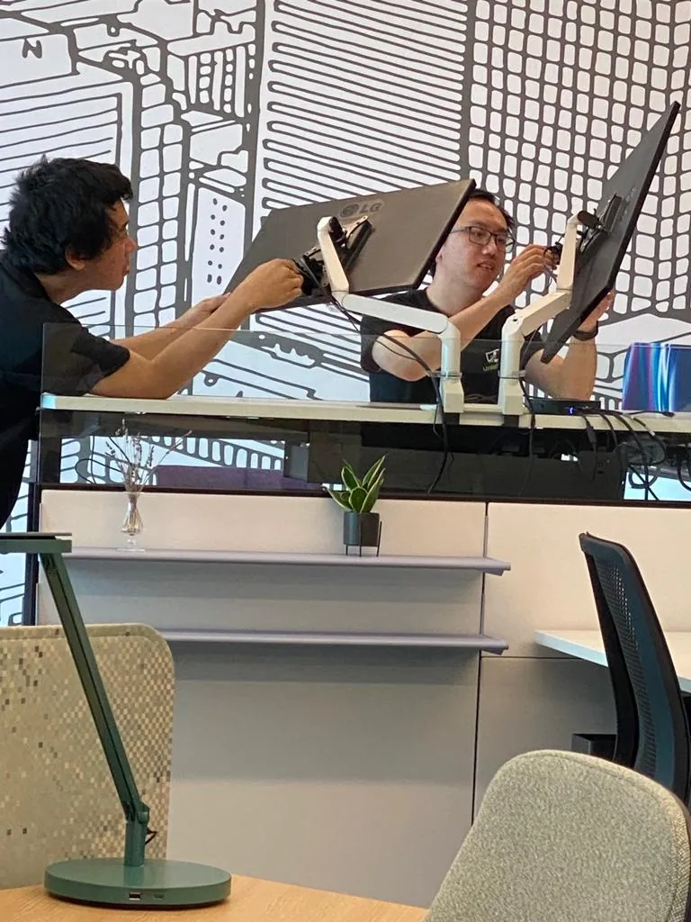 Professional monitor installation with dual screen setup and ergonomic mounting in office environment.