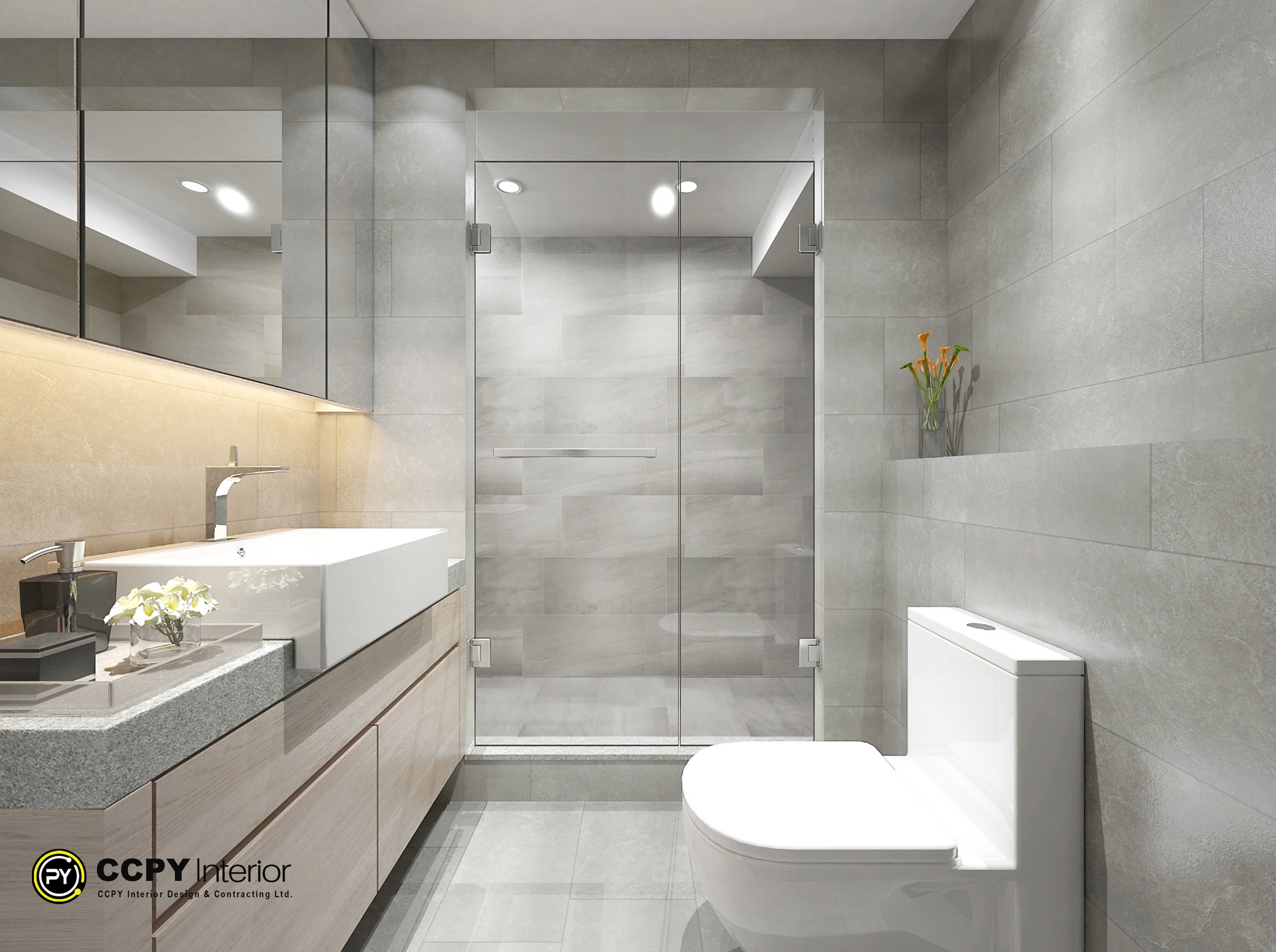 his sleek, modern bathroom design maximizes functionality in a compact layout, highlighting an efficient three-quarter wet room configuration optimized for tight spaces.Key Design FeaturesSpace-Saving Layout: Built with a linear layout that positions the floating vanity, toilet, and frameless glass walk-in shower along parallel paths to optimize narrow floor plans.Monochromatic Material Palette: Clad in large-format, matte grey porcelain stone-effect wall tiles that create continuous surfaces and reduce visual clutter.Integrated Storage: Features a seamless wood-grain floating vanity beneath a large-format integrated white vessel trough sink, paired with a matching mirrored upper medicine cabinet.Ambient Lighting Layout: Utilizes warm under-cabinet LED strip lighting along the vanity backsplash alongside ceiling-recessed spotlights to make the grey surfaces feel warm and expansive
