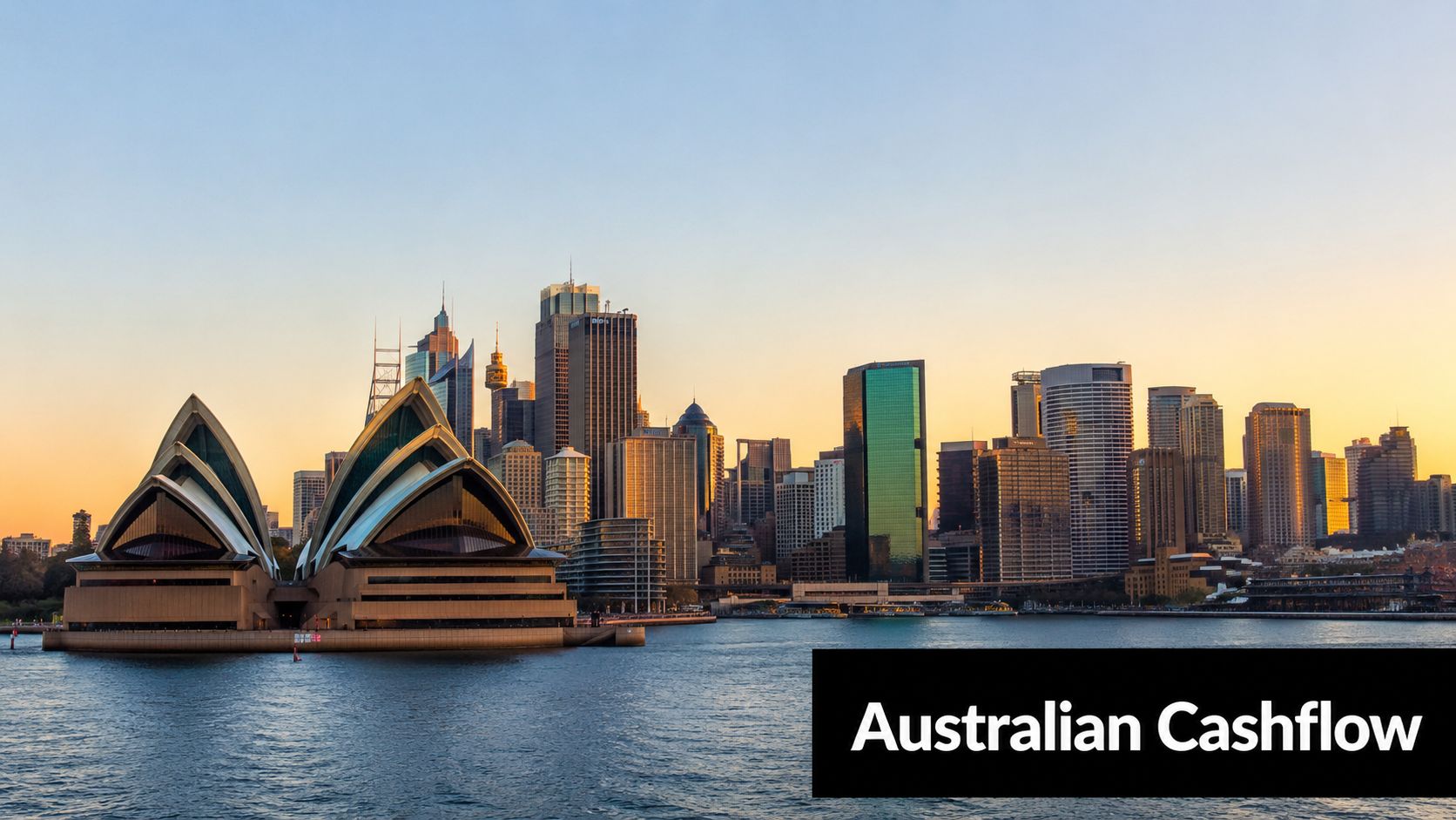 A wide angle view of the Sydney Opera House and the Sydney city skyline at sunset.