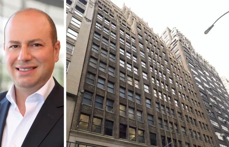 Tall modern skyscraper with vertical lines, viewed against a clear blue sky.