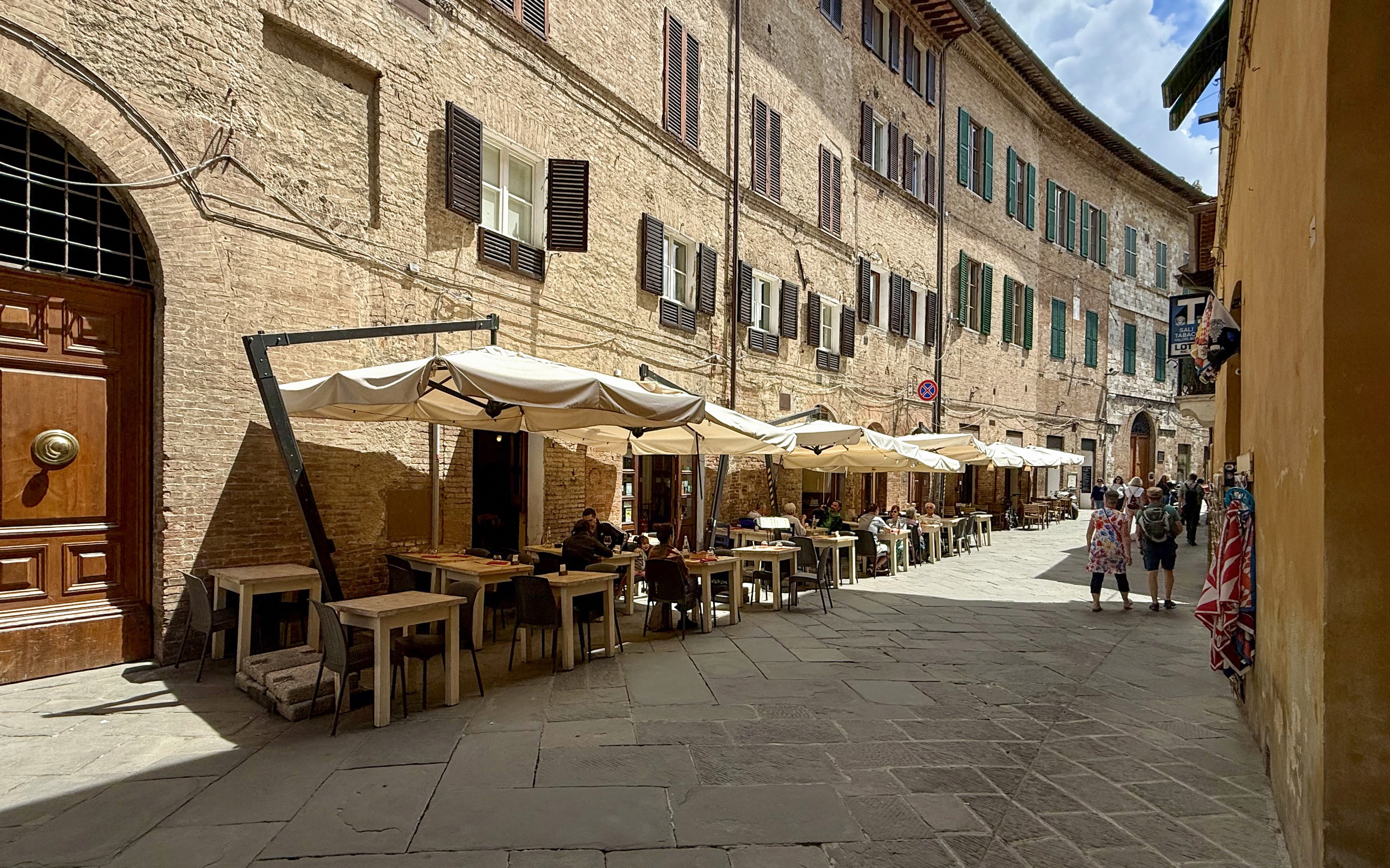 Outdoor seating at a cafe in Siena, Italy, ideal for pasta cooking classes.