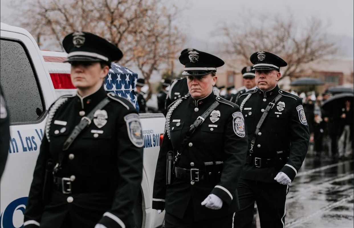 two man walks near USA flag wall