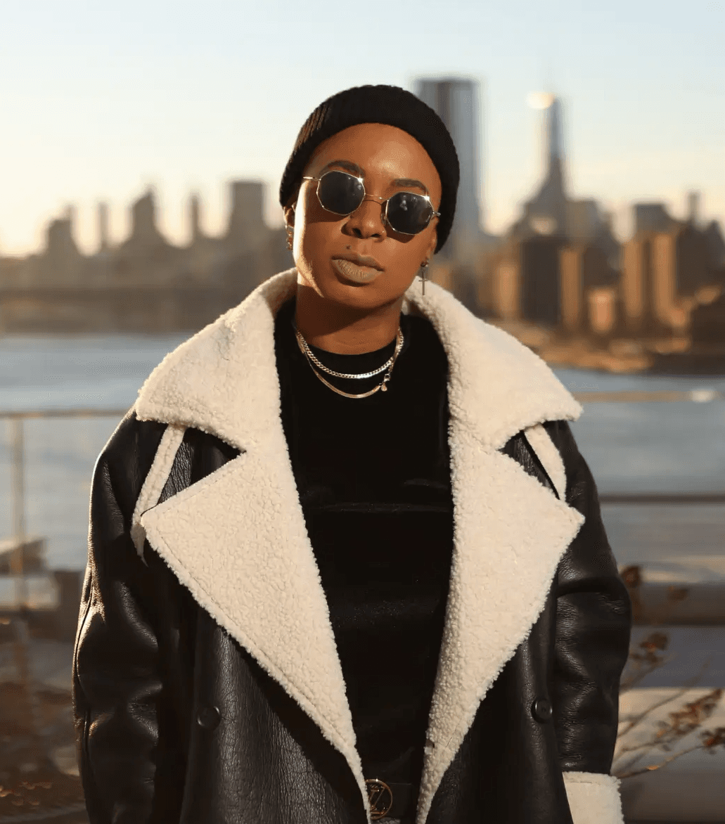 Post Malone, a smiling man with a beard and tattoos, wearing a denim jacket, posed against a neutral background.