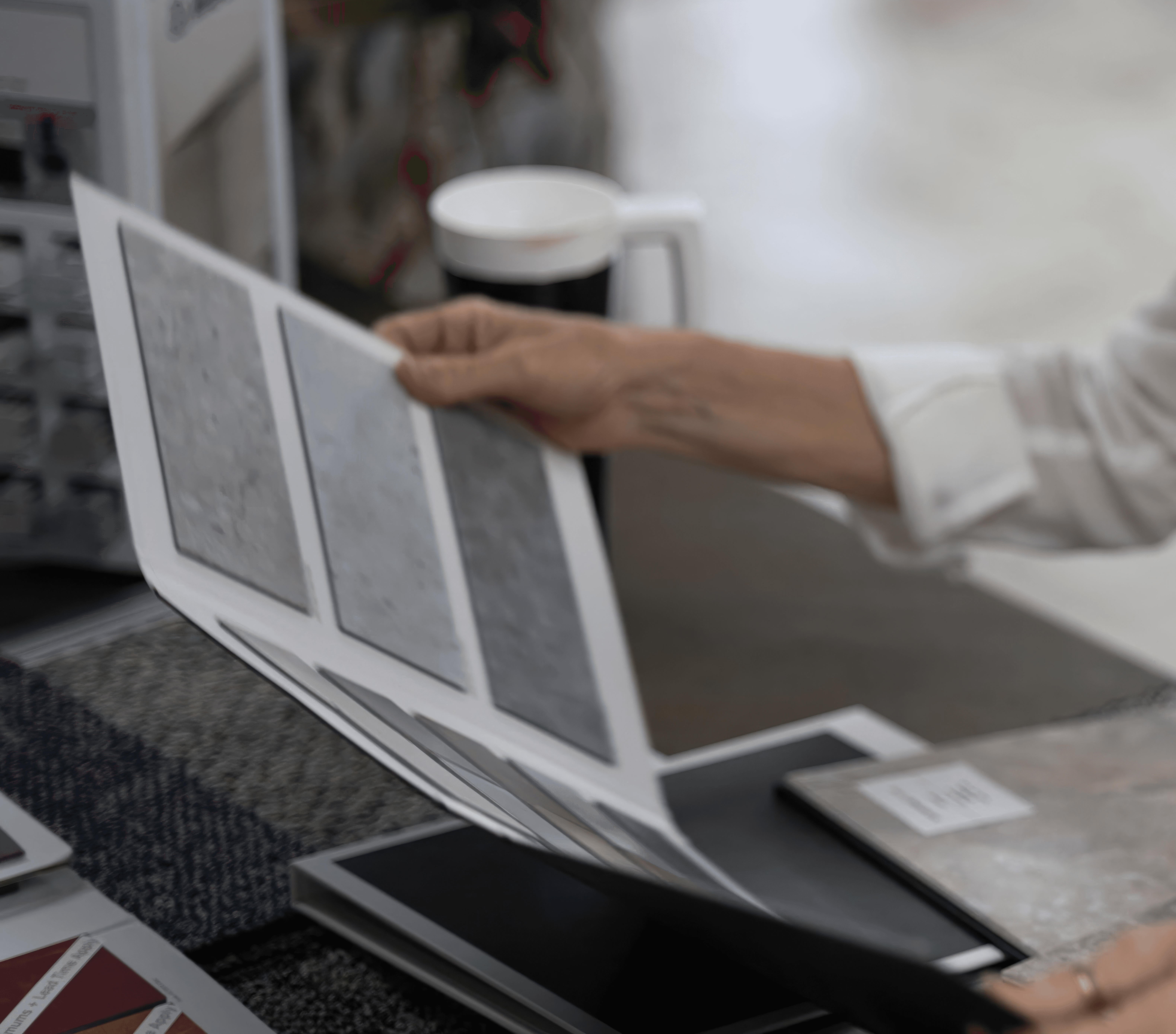 Flipping through a flooring sample book of tile and vinyl swatches