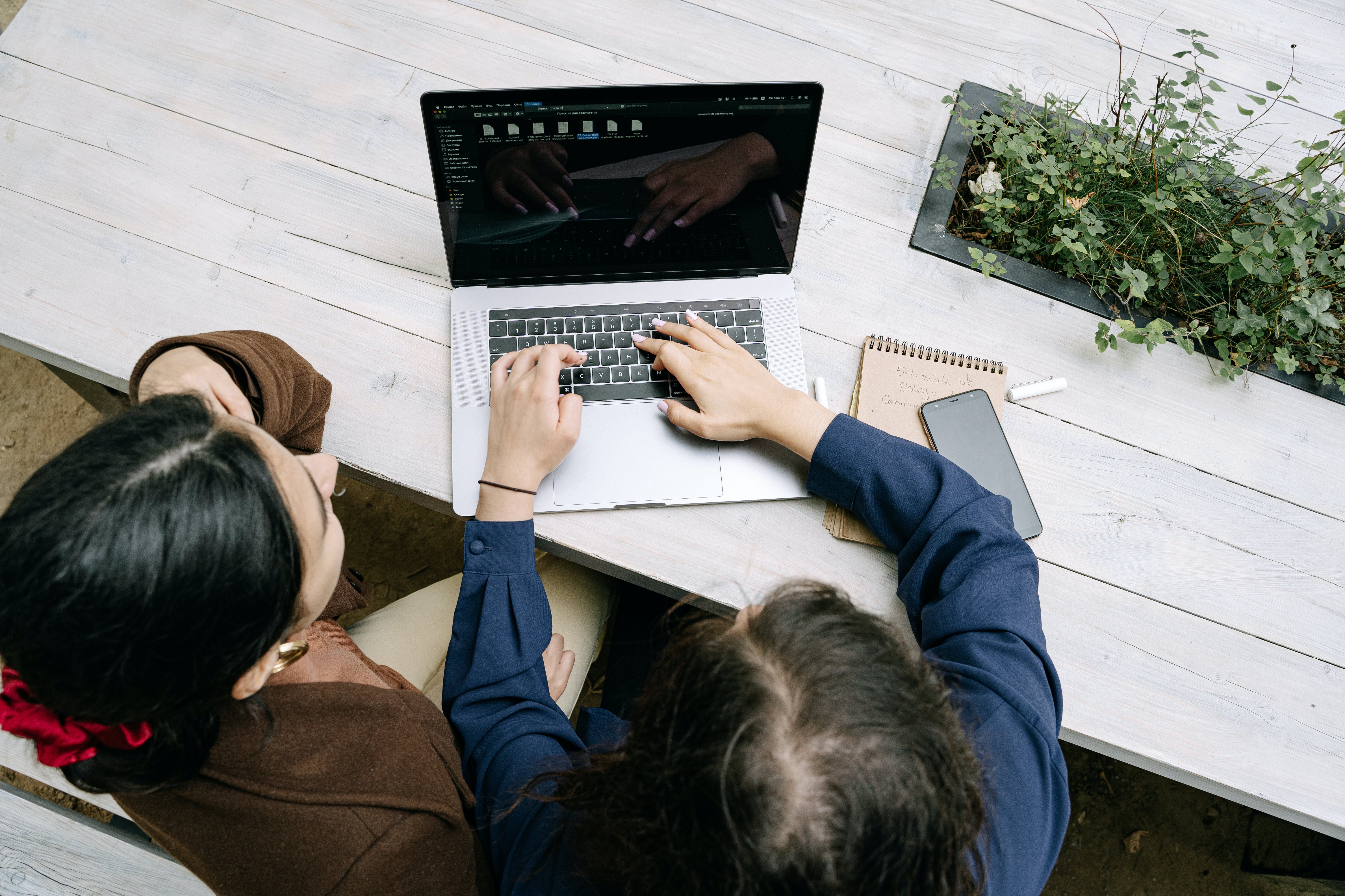 Overheard shot of colleagues using a laptop to reach out using cold emails