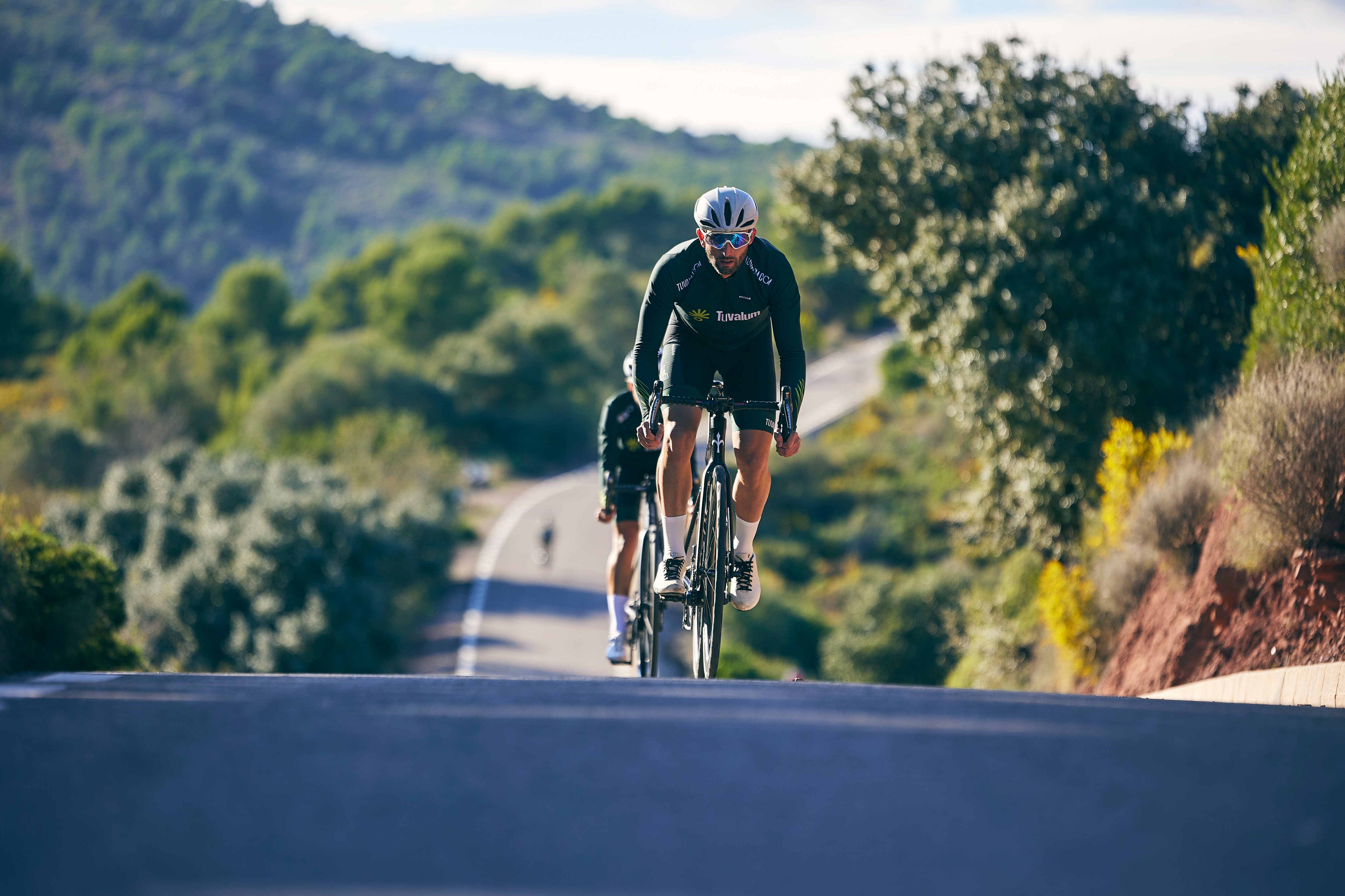 a man riding a bike down a curvy road