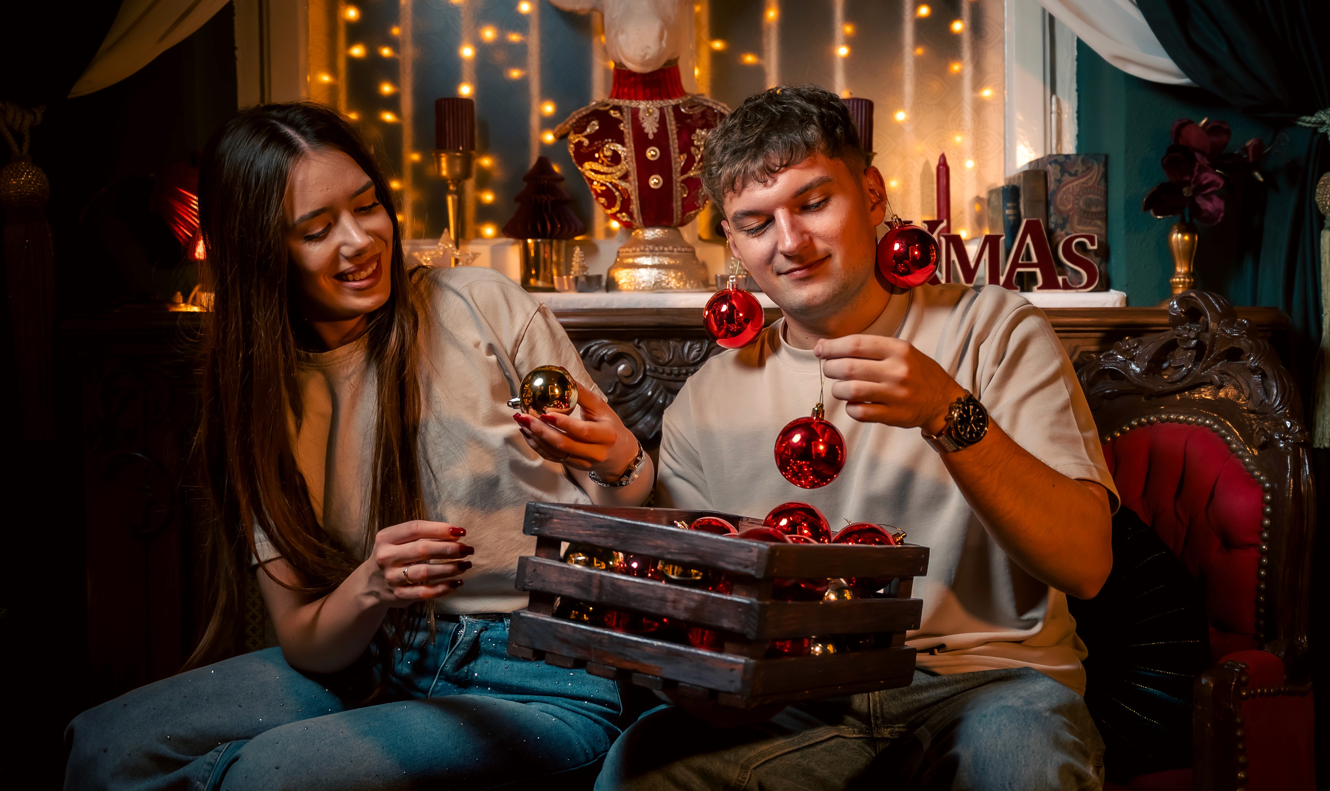 Cuplu deschizând cadouri de Crăciun, fotografie emoțională într-un decor de iarnă.