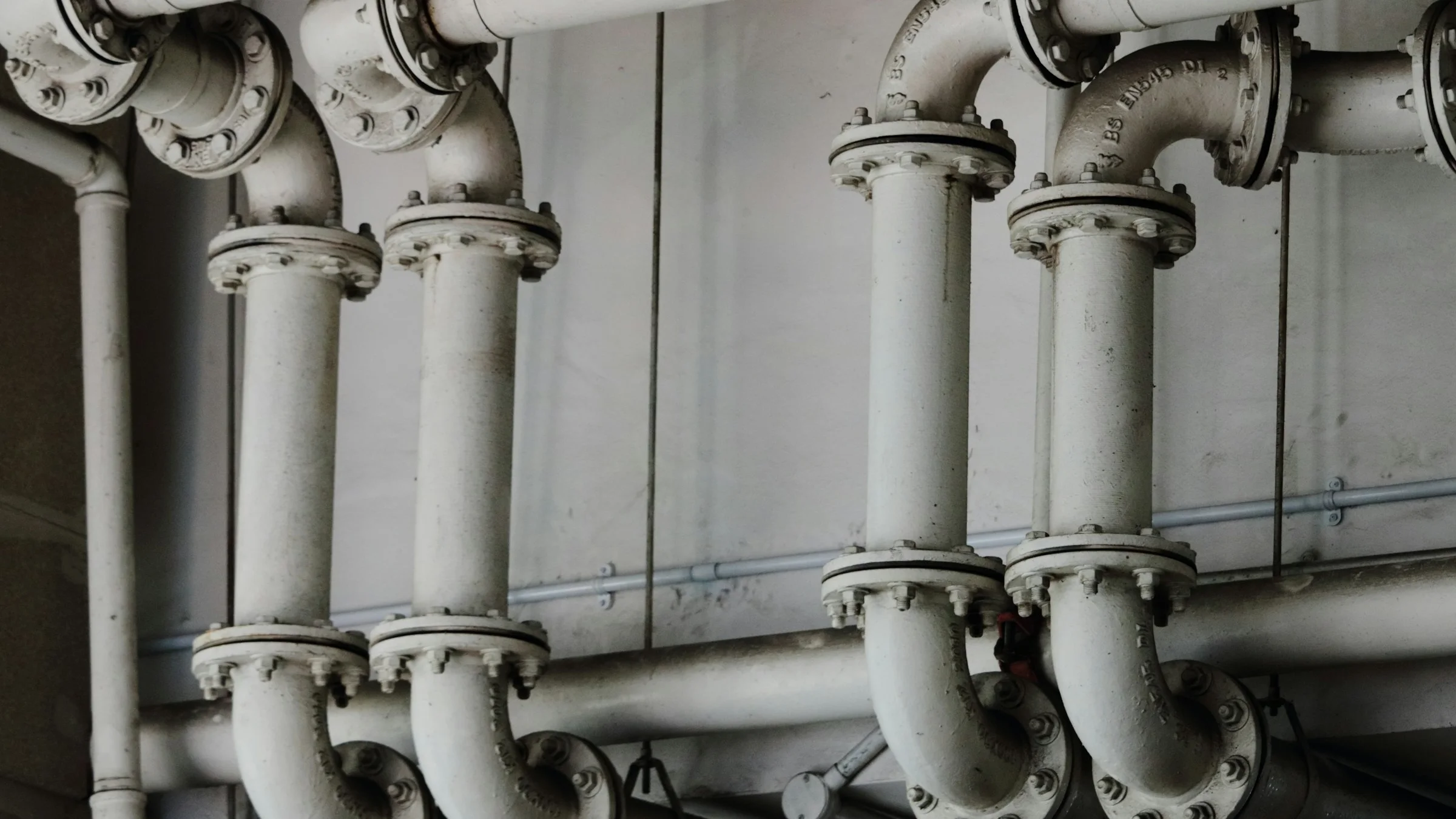 Black and white close-up of steel process pipes inside an industrial plant