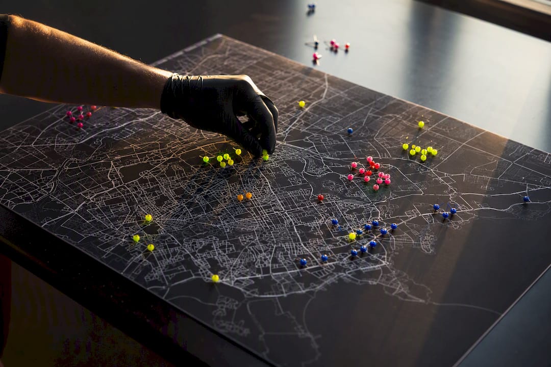 Hands adjusting suburb map pins