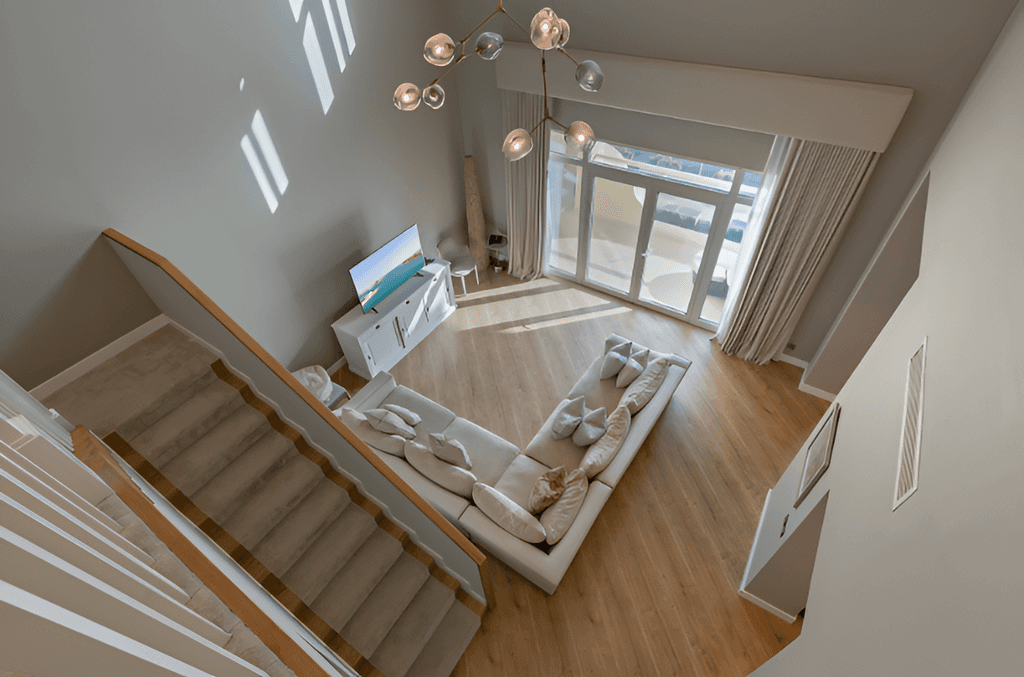 Cozy living room at Shoreline Apartments, equipped with a couch, a television, and stairs.