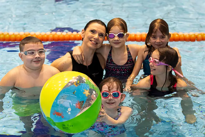 deti s balonem usmivajici se v bazenu