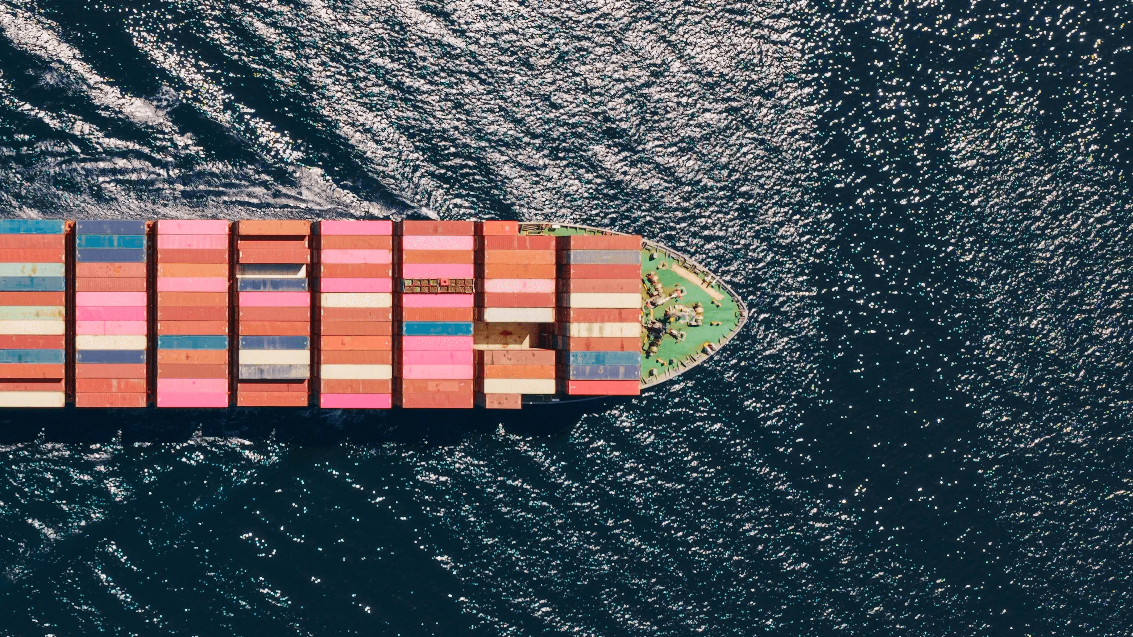 Vue aérienne d’un porte-conteneurs transportant des conteneurs colorés en mer.