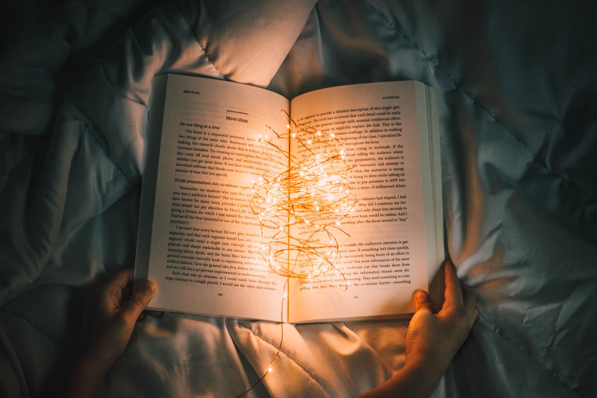 Open book with lit Christmas lights in between pages
