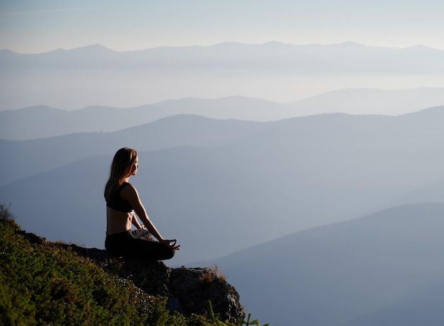 Woman doing yoga under a clear sky during a mindful sobriety routine, symbolizing alcohol tracking, healthy habits, and the Soberly app’s approach to smart sobriety.