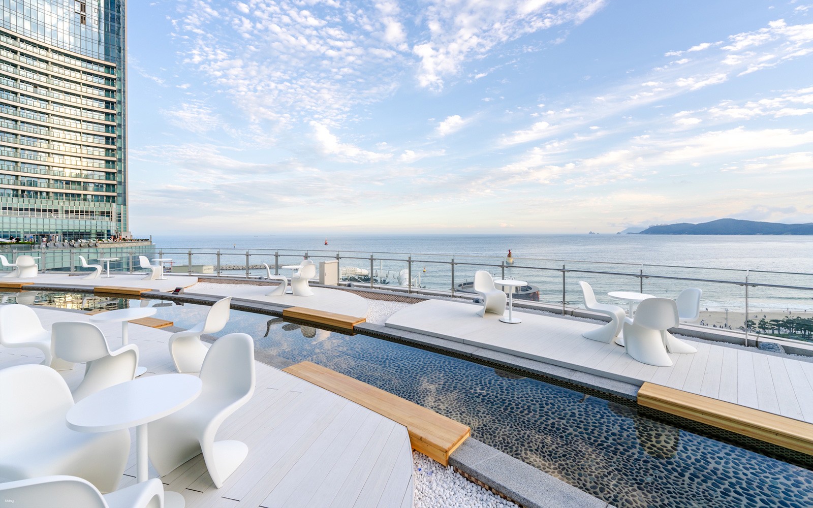 Открытая терраса в Club D Oasis с современной мебелью и мелкими водоемами у моря.